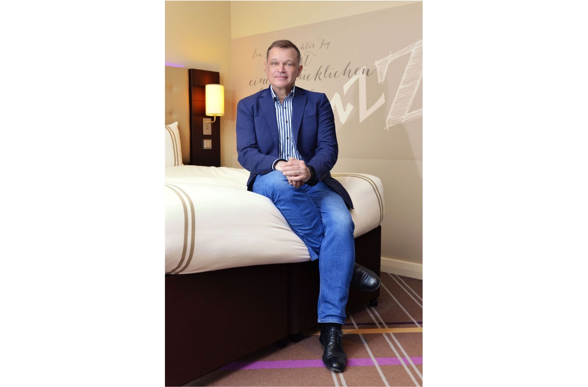 Juergen Hoch sitzt auf einem Bett des Premiere Inn