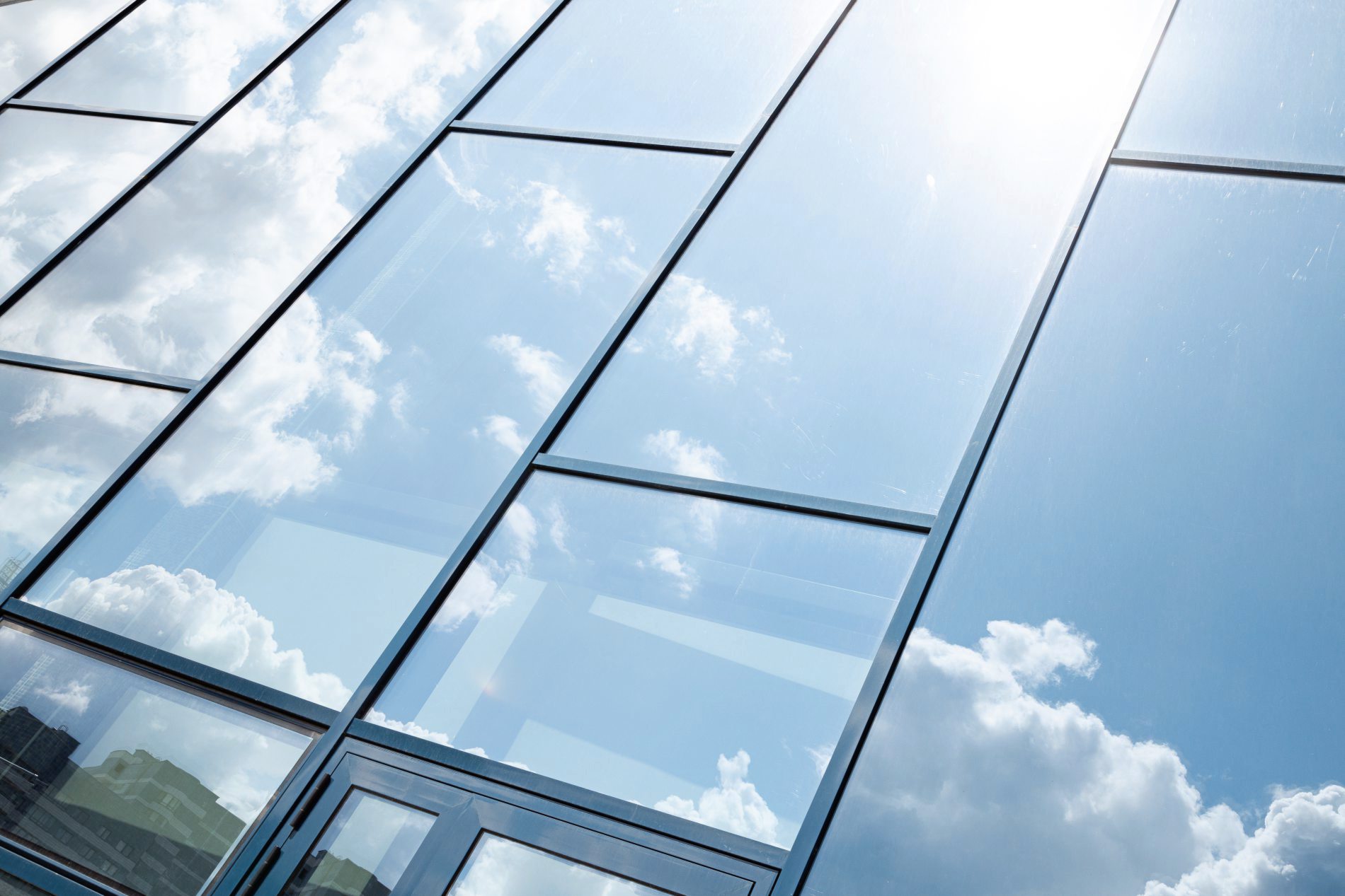 Glass building facade with blue sky reflection