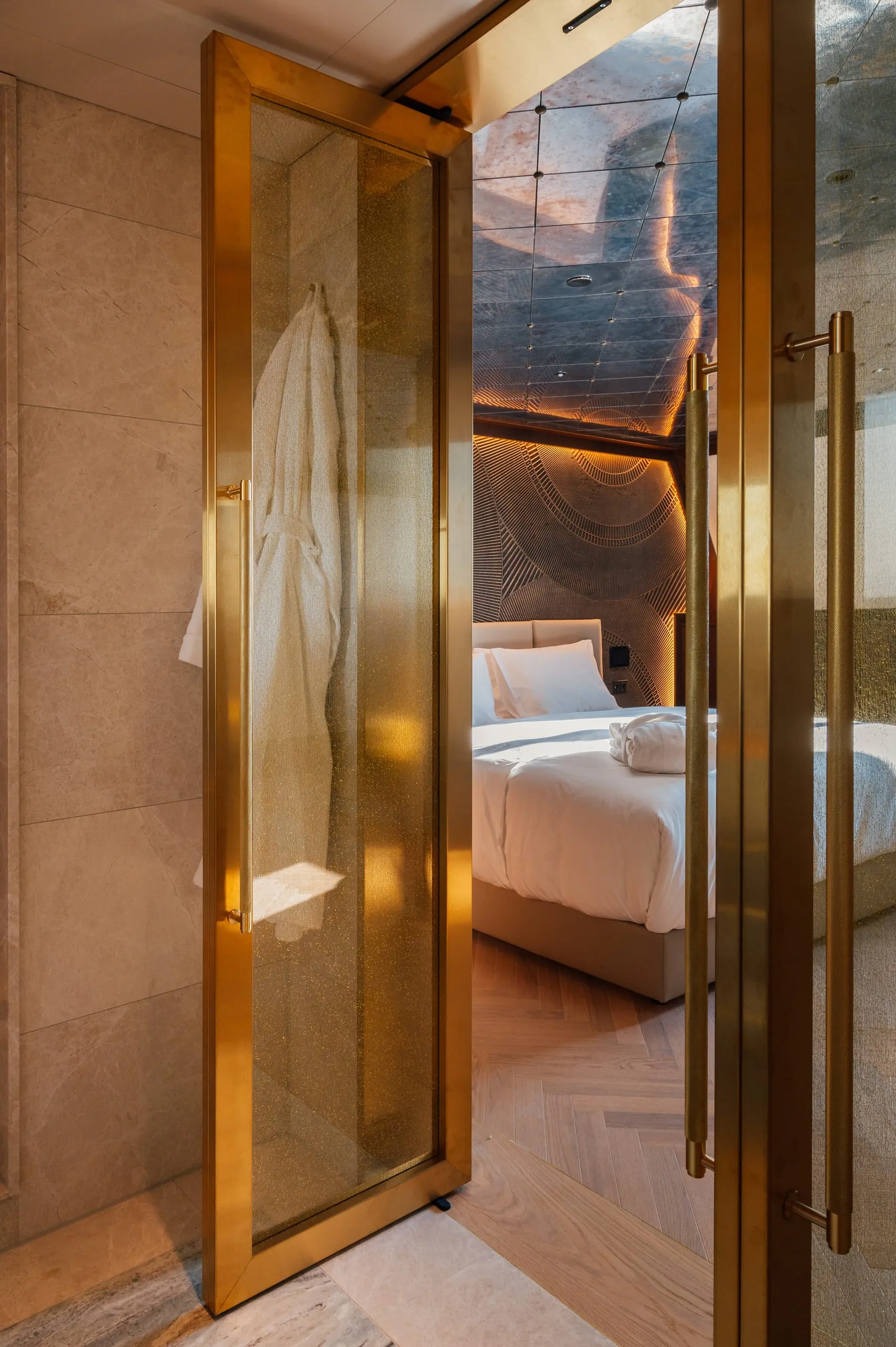 Hotelzimmer mit Bett, schwarzer Decke und einer Kupfertüre