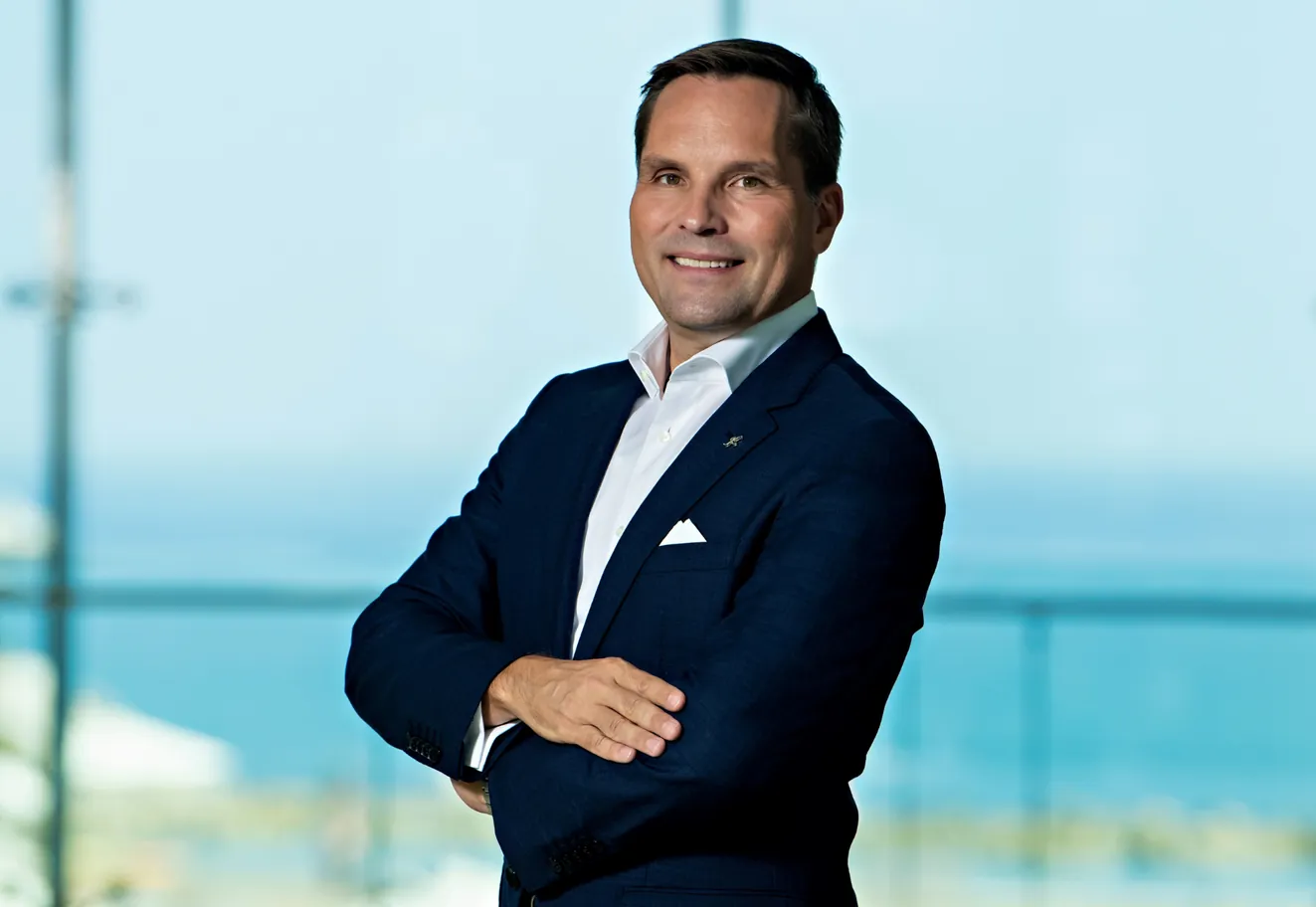 Carsten Wiegandt blickt lächelnd und mit verschränkten Armen in die Kamera