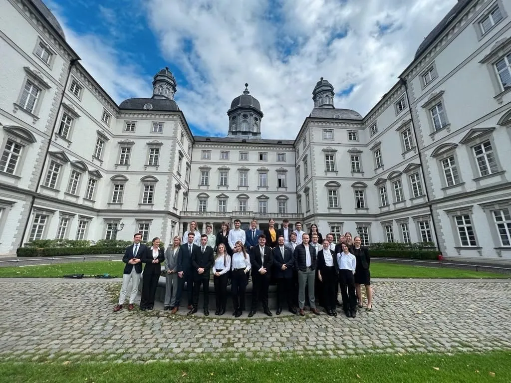 Azubis vom Althoff Grandhotel Schloss Bensberg lächeln vor dem Schloss in die Kamera