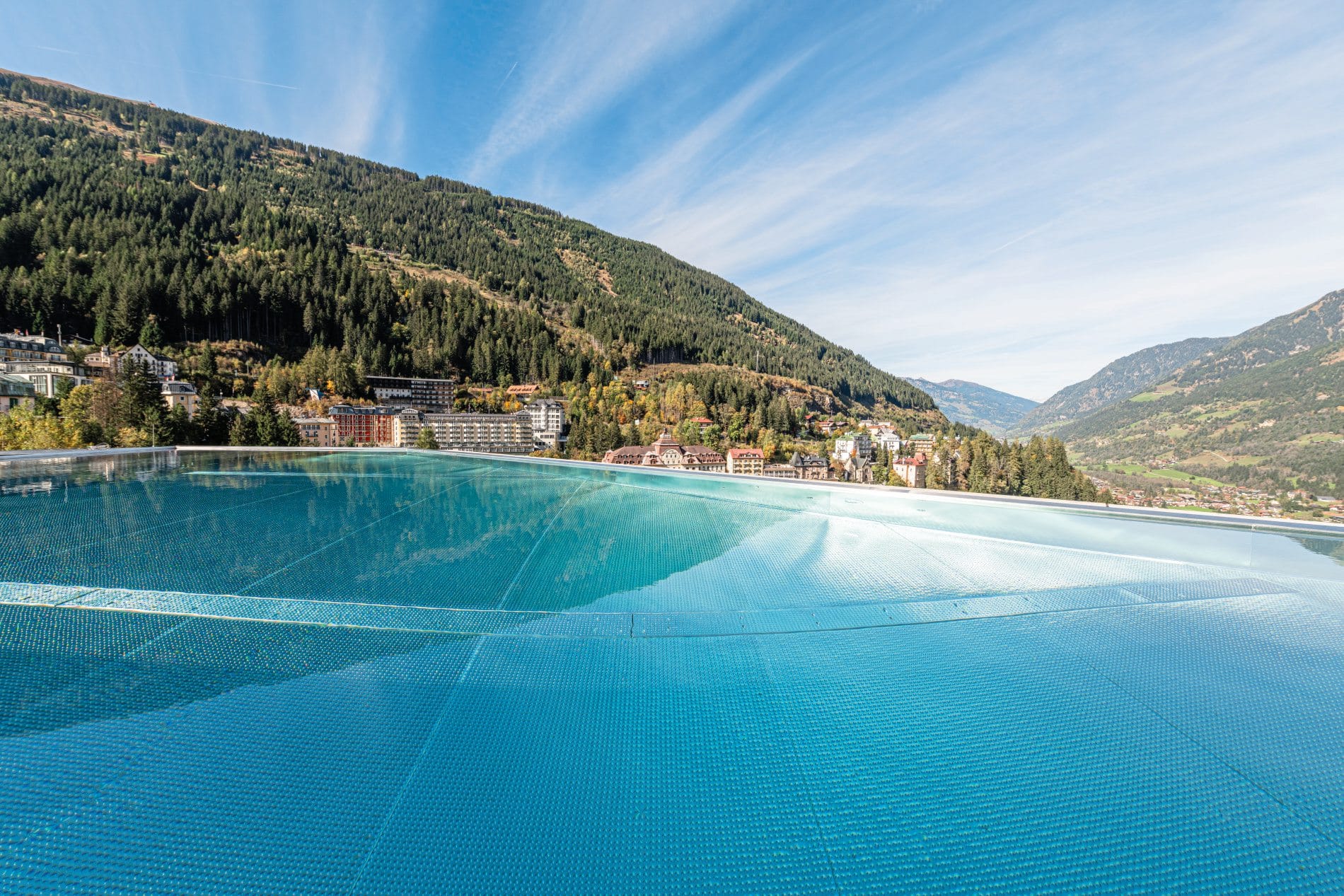 Blick vom Infinity Pool auf die Berge und den Kurort Bad Gastein in Österreich.