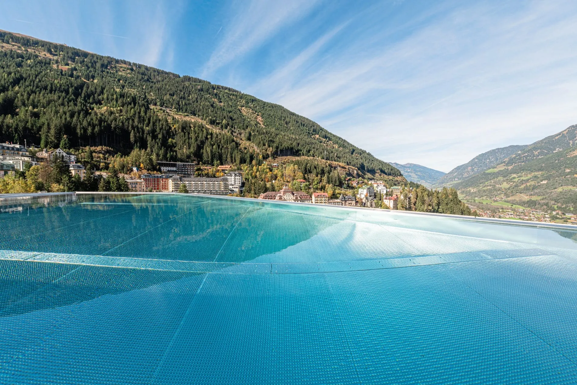 Blick vom Infinity Pool auf die Berge und den Kurort Bad Gastein in Österreich.