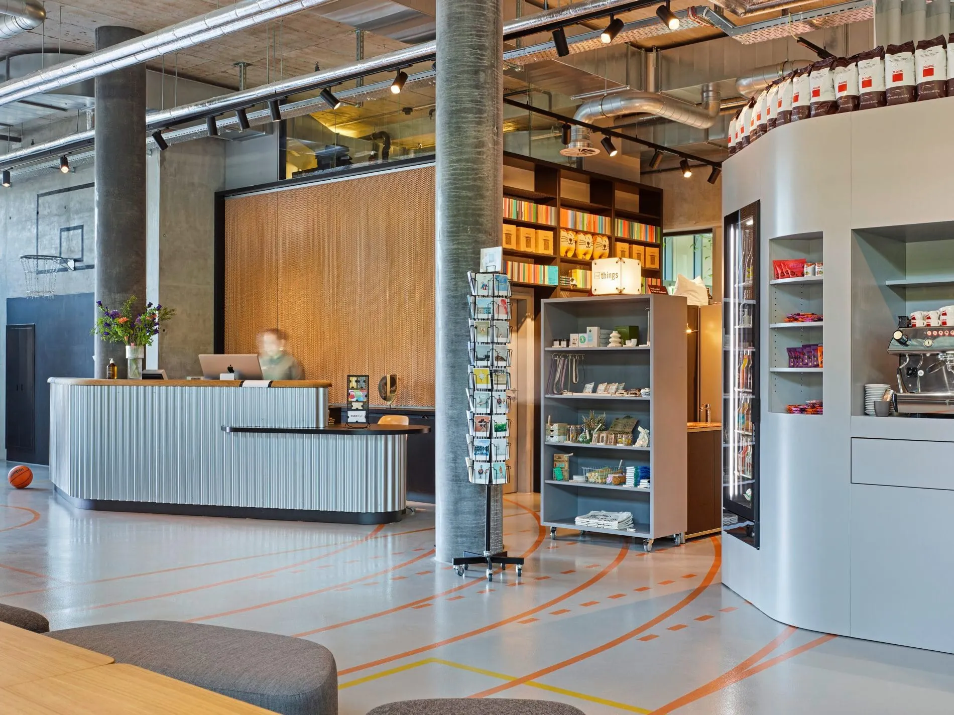 Der Empfangsthresen in Form eines Bumerangs, zwischen Basketballkorb und Snacks für die Gäste.