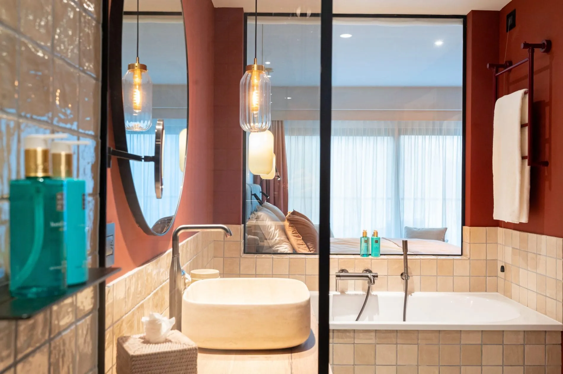 Badbereich mit Blick auf das dahinter liegende Bett.