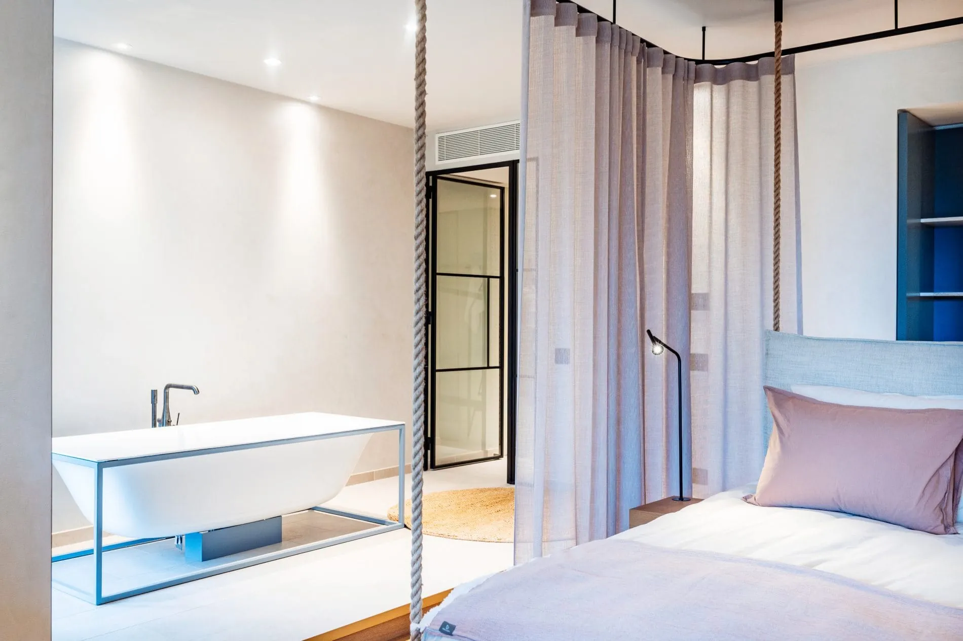 Zimmer mit Schlafbereich und freistehender Badewanne.