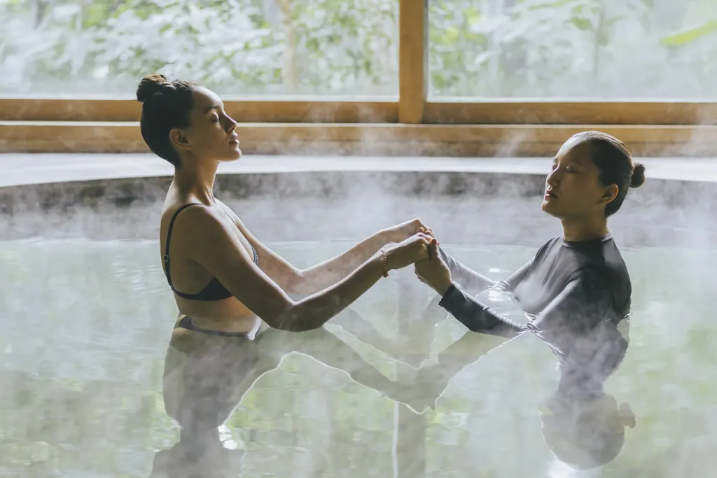 Zwei Frauen genie&szlig;en die wohltuende Watsu-Therapie, die K&ouml;rper- und Wassertherapie vereint, um tiefenentspannende Erlebnisse zu schaffen.