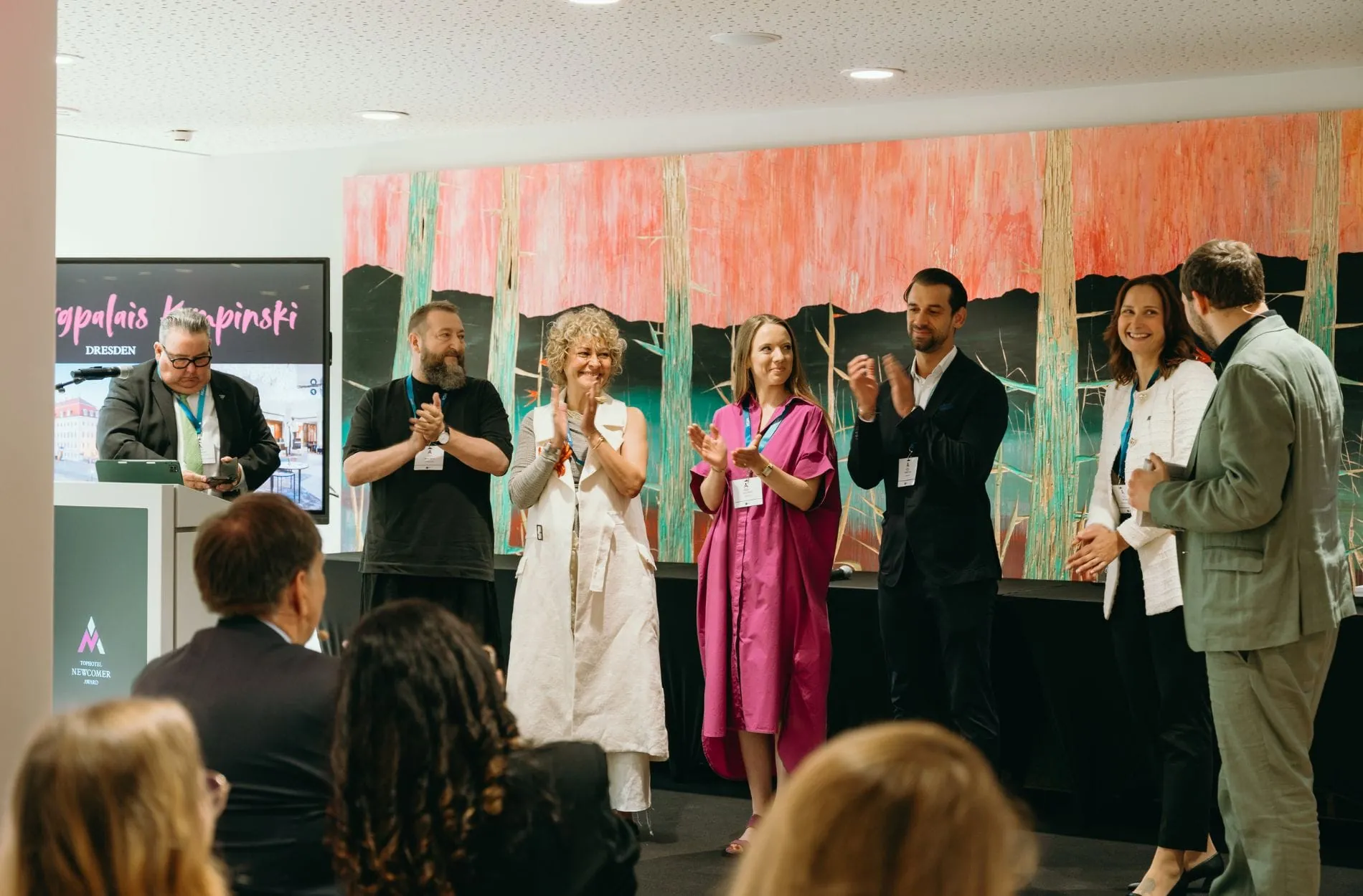 Moderator Max Herrmannsdörfer (rechts) verkündet den Sieger in der Kategorie "Hotel-Reopening City": Das Taschenbergpalais Kempinski in Dresden, das mit Marlen Seidel (Zweite von rechts) vertreten ist.