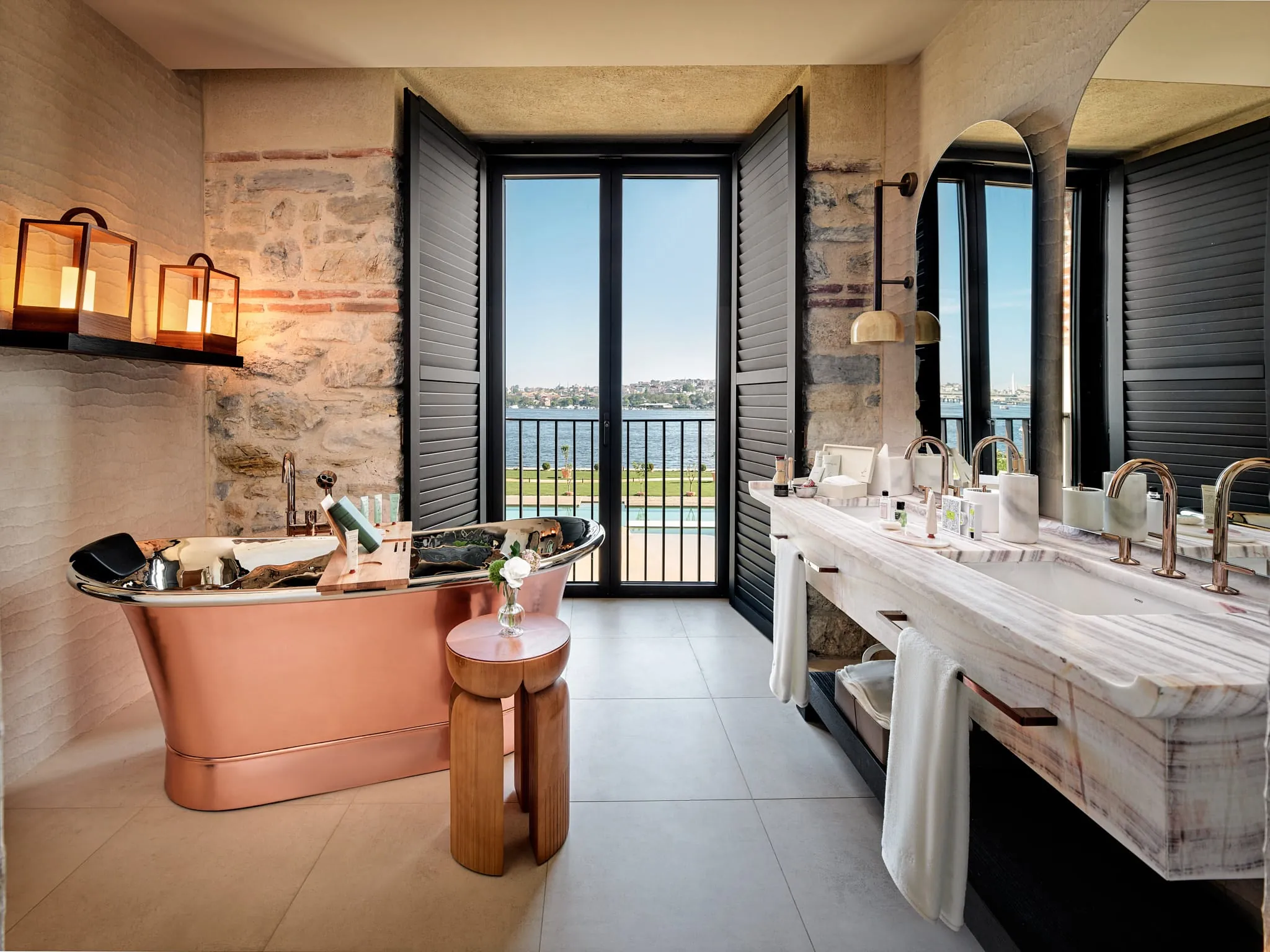 ... mit freistehender Kupferwanne, Doppelwaschbecken und eleganter Gestaltung im Stil des Hotels.