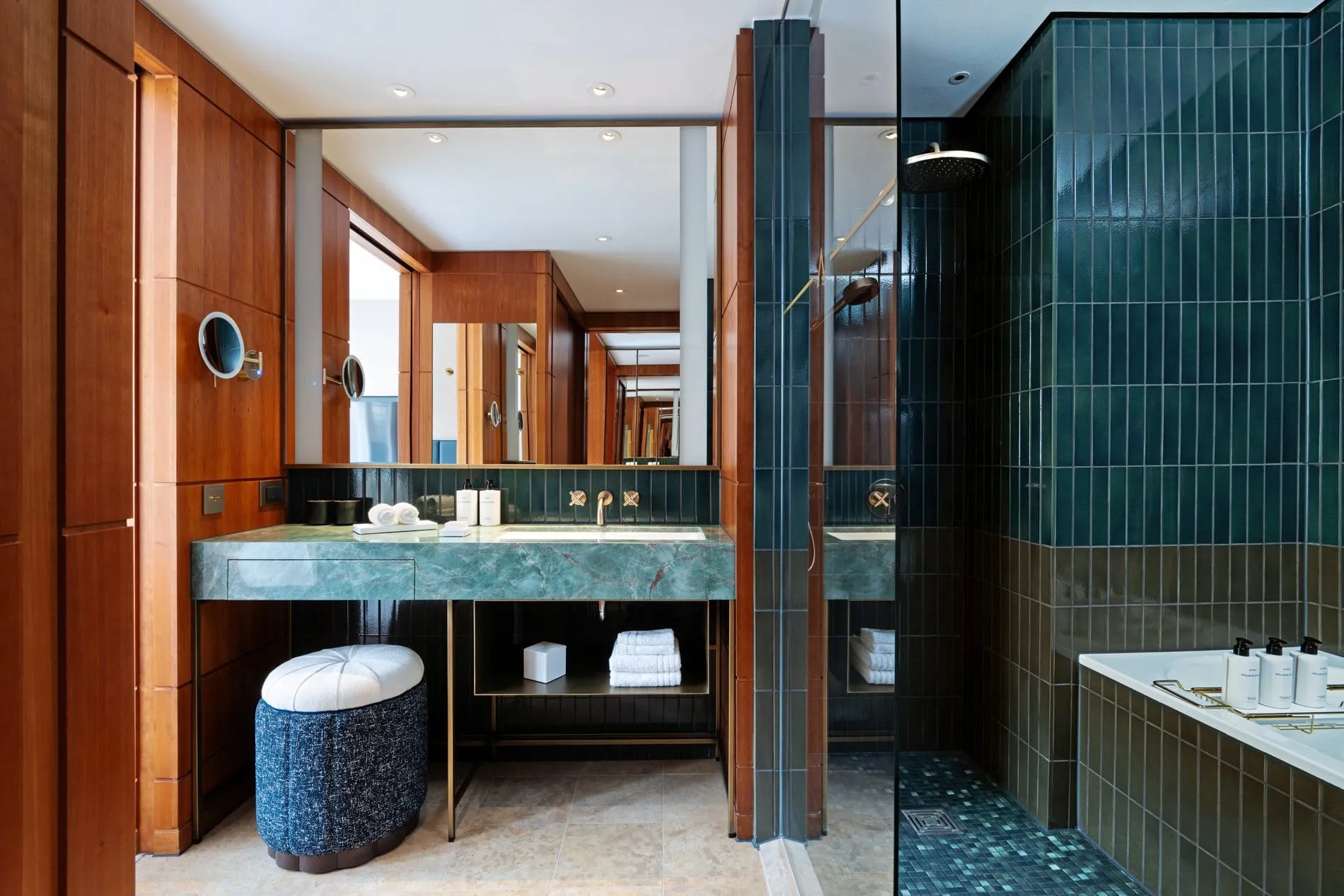 Jedes Zimmer verfügt über eine Badewanne und eine Erlebnisdusche, die Waschbecken sind aus dunkelgrünem Granit und mit goldfarbenen Wasserhähnen ausgestattet.