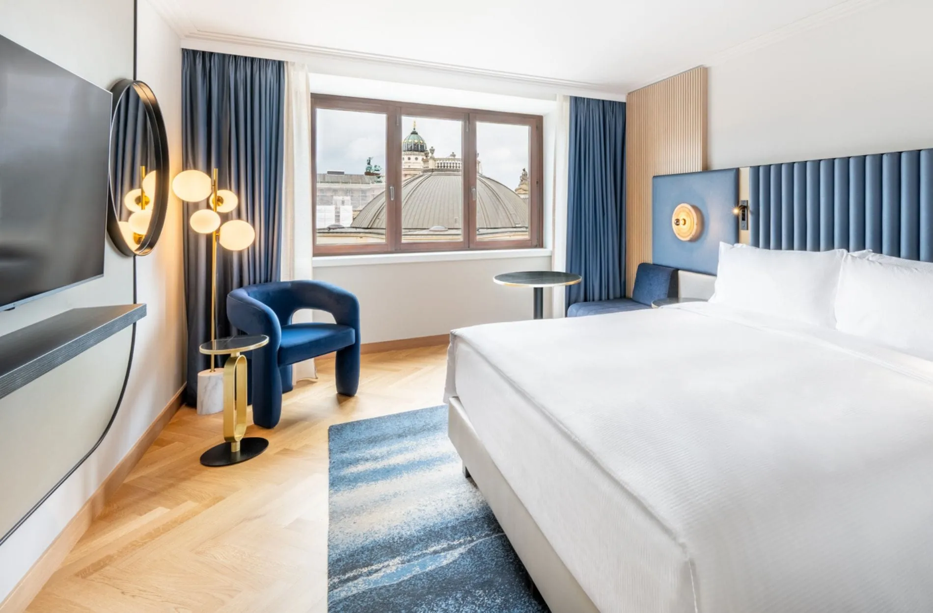 Ganz auf den Gendarmenmarkt abgestimmt: Die neugestalteten King-Executive-Plus-Zimmer im Hilton Berlin mit Fischgrätparkett, blauen Kopfteilen und einem passendem blauen Teppich.