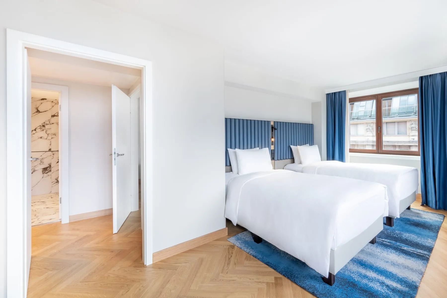 Blau- und Naturtöne bestimmen das Design: Die Two-Bedroom-Executive-Suite mit zwei Einzelbetten im Hilton Berlin.