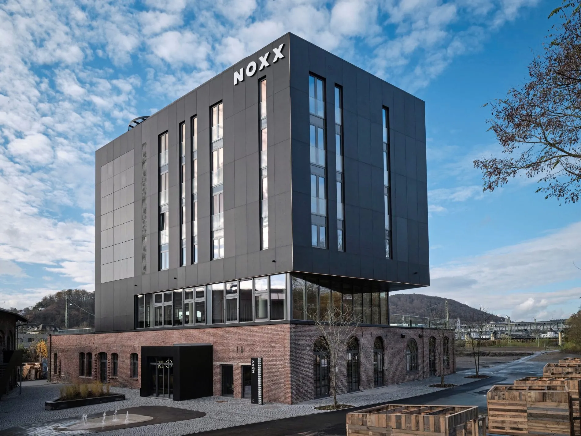 Die dunklen Stahlplatten der Hotelfassade wurden mit schwarzen PV-Elementen kombiniert. Die Optik ist ein Verweis auf historische Dampflokomotiven.