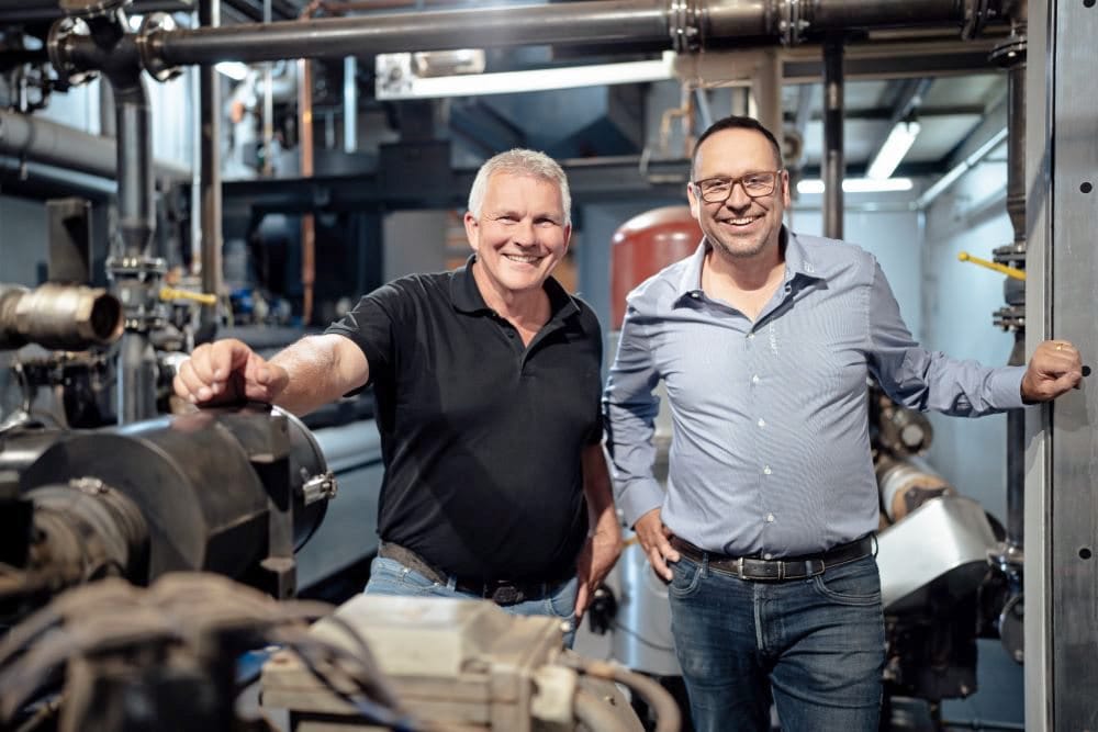 Hotelier Herbert Stemp (links) und Re2-Geschäftsführer Thomas Bleul zeigen die Holz-Kraft-Anlage im Hotel Das Stemp.