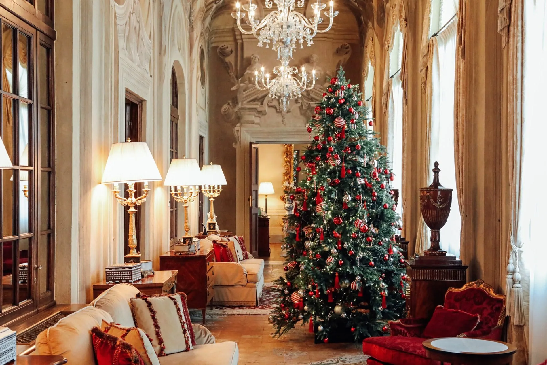 eihnachtsbaum in der Lobby des Four Seasons Hotel Firenze mit Kronleuchtern und historischen Fresken.