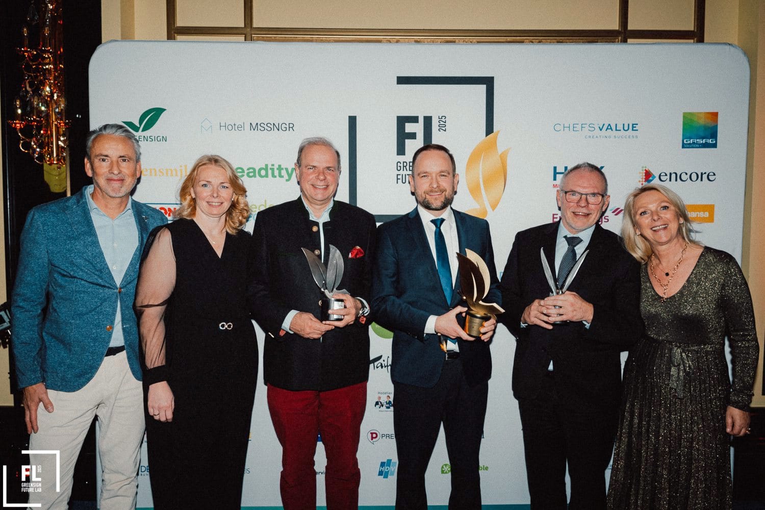 Green Monarch Award – Kategorie "Restaurant": Ein Vertreter von Klüh Catering (Vierter von links) mit der Siegestrophäe im Kreise von (von links) Urban Uttenweiler (HGK), Anne Schiefer (Green Sign), Clemens Ritter von Kempski (Ritter von Kempski Privathotels), Michael Buchna (Buchnas Landhotel Saarschleife) und Suzann Heinemann (Green Sign).