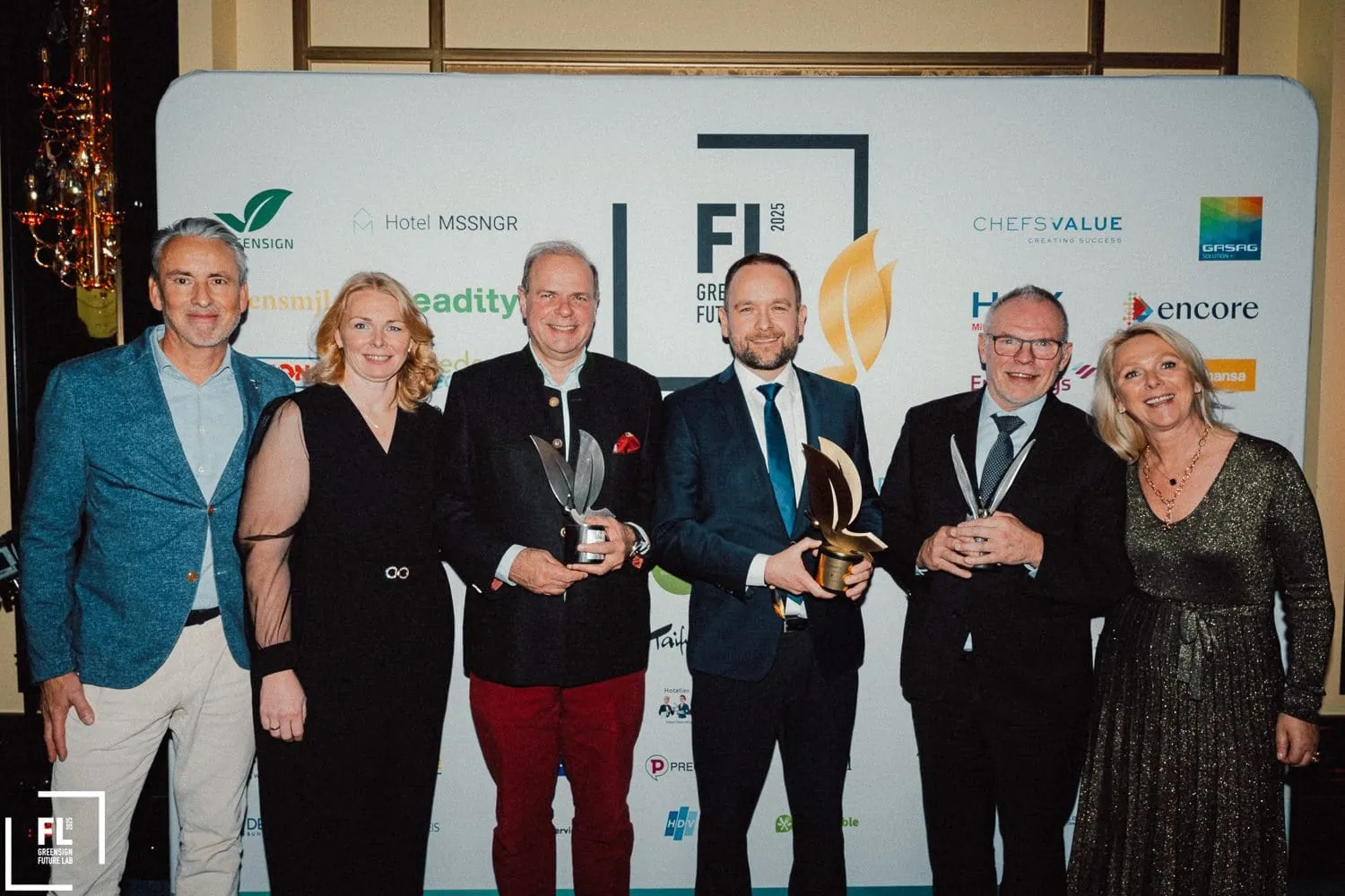 Green Monarch Award – Kategorie "Restaurant": Ein Vertreter von Klüh Catering (Vierter von links) mit der Siegestrophäe im Kreise von (von links) Urban Uttenweiler (HGK), Anne Schiefer (Green Sign), Clemens Ritter von Kempski (Ritter von Kempski Privathotels), Michael Buchna (Buchnas Landhotel Saarschleife) und Suzann Heinemann (Green Sign).