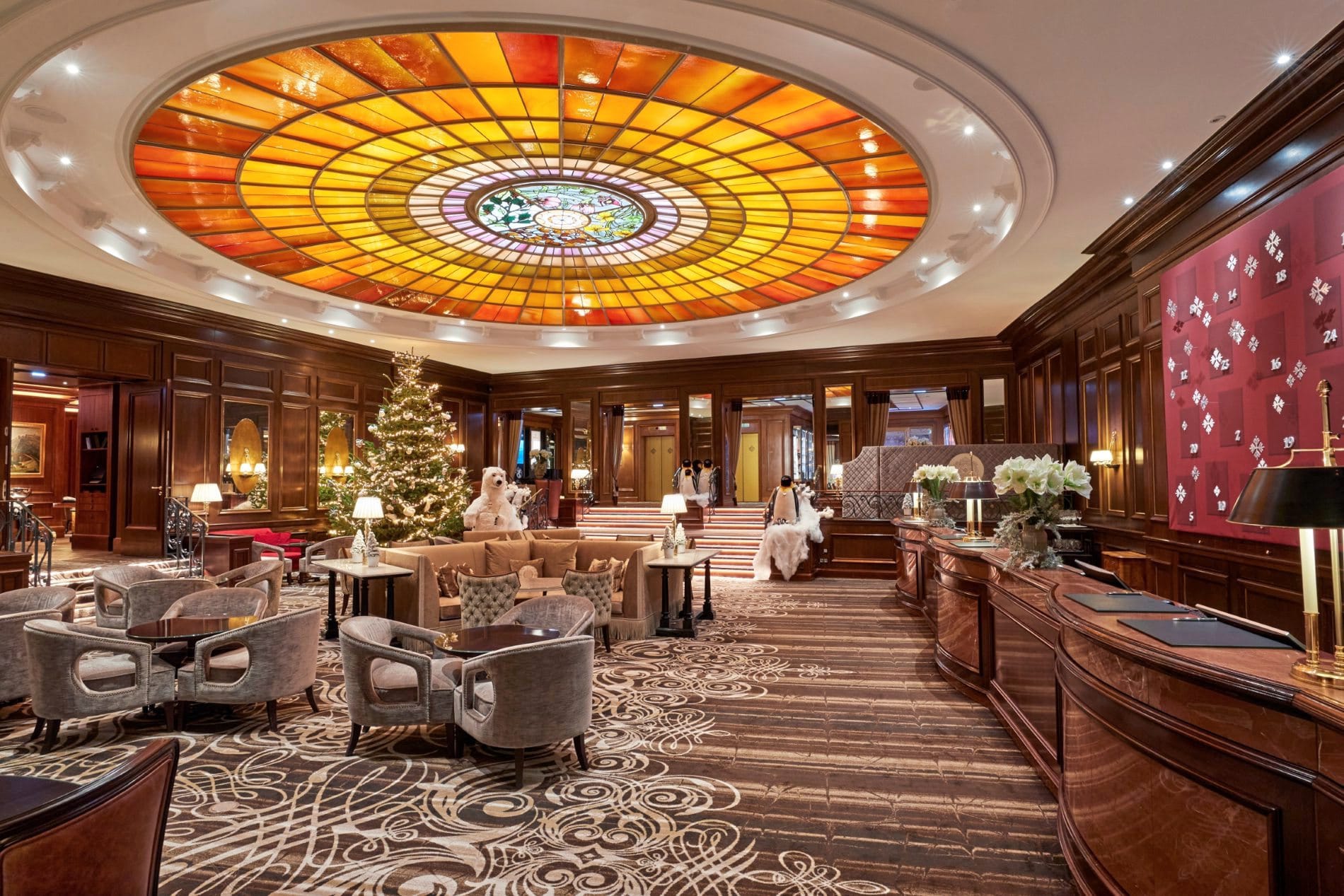 Weihnachten im Hotel Vier Jahreszeiten Kempinski München: Der festlich geschmückte Weihnachtsbaum in der Lobby setzt ein stimmungsvolles Zeichen für bayerische Weihnachtstradition und herzliche Gastfreundschaft.