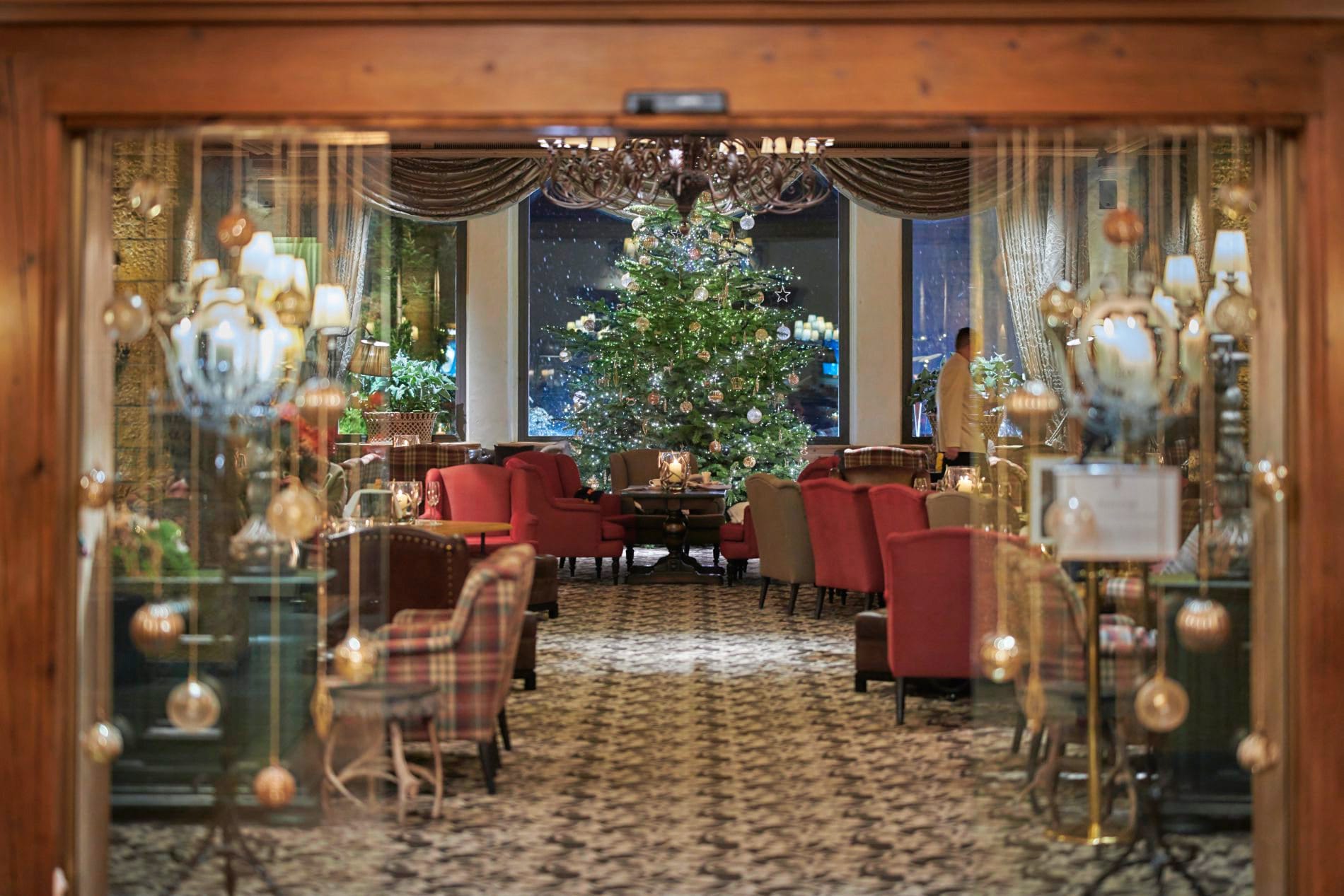 Der stilvoll geschmückte Weihnachtsbaum verbreitet festliche Stimmung in der Lobby Bar des Gstaad Palace.