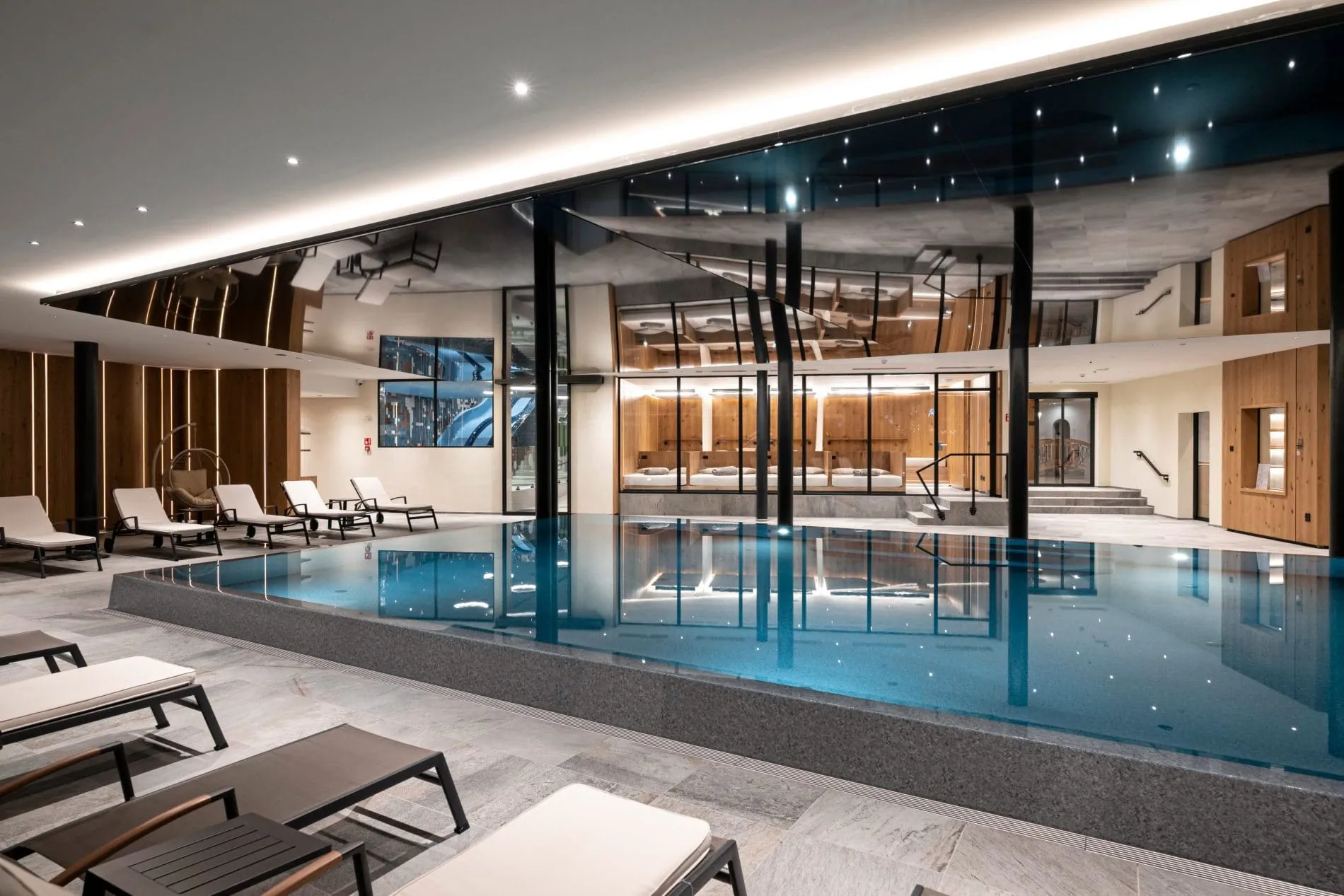 Innenpool mit Sternenhimmeldecke, Liegestühlen und Holzverkleidung.