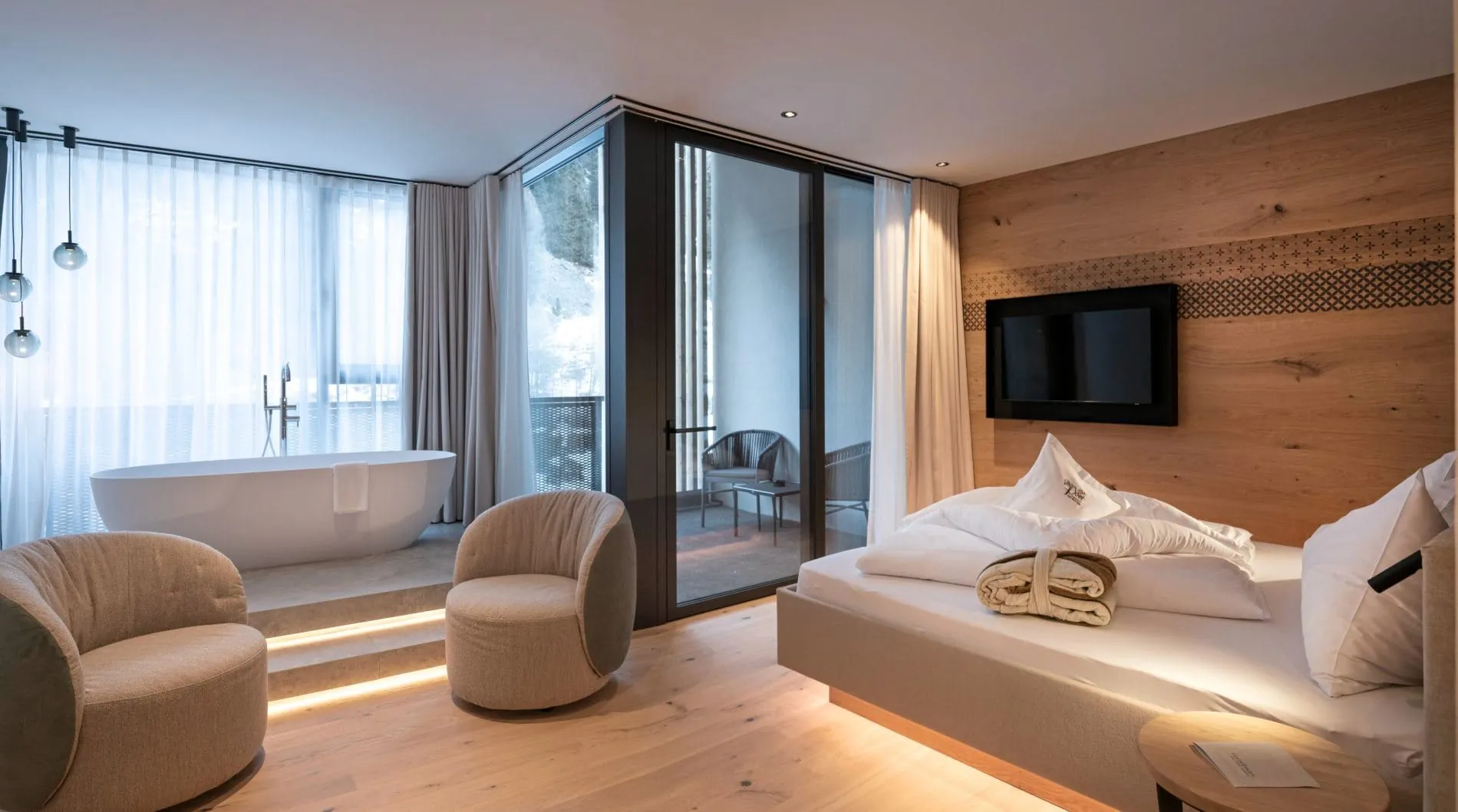Juniorsuite mit Doppelbett, freistehender Badewanne und Balkonzugang.