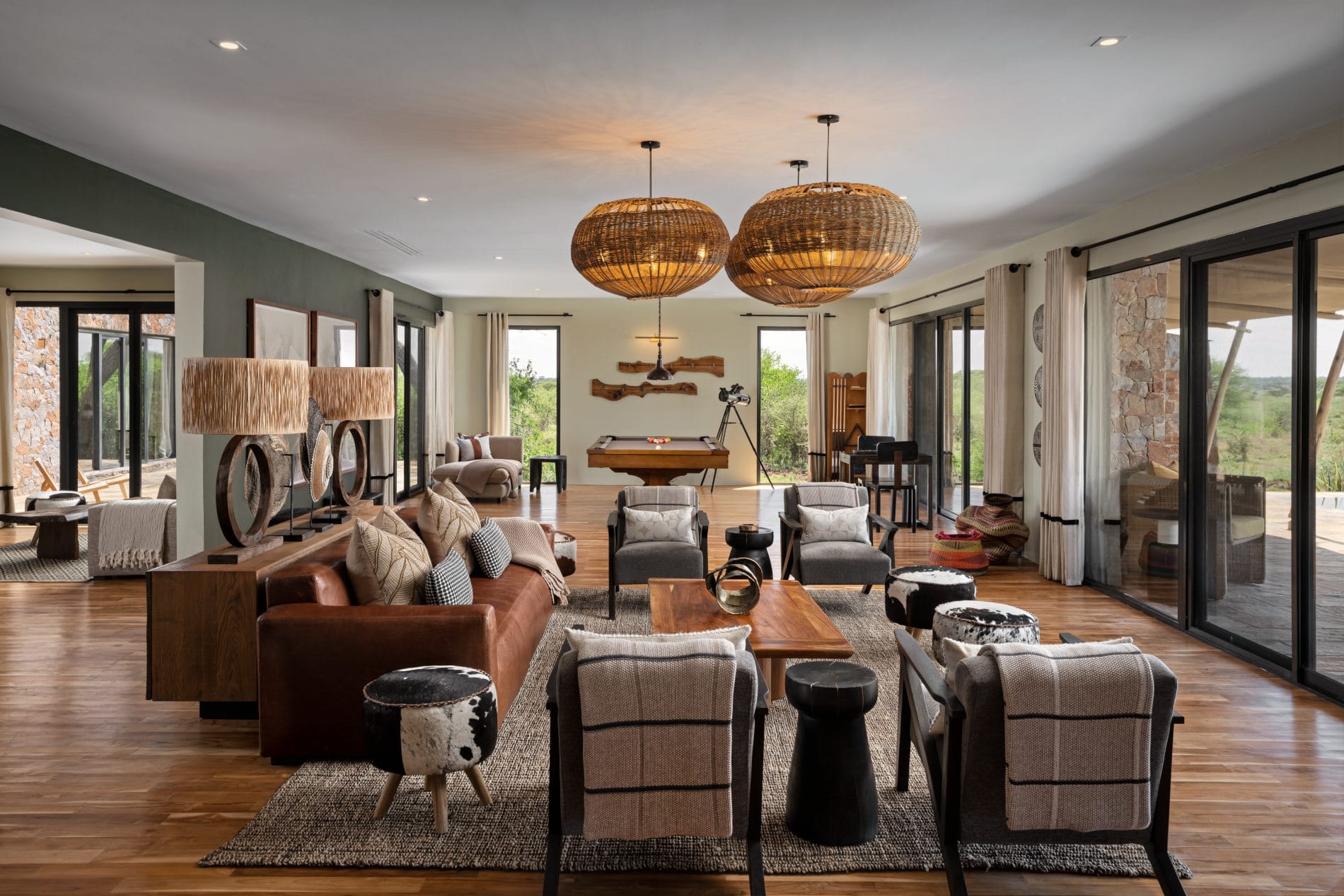 Luxuriöse Villa-Lounge mit Ledersofa, Rattanlampen und Billardtisch im Mapito Safari Camp.