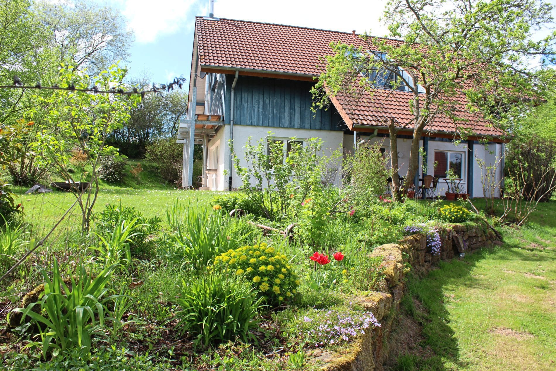Der Garten des Landhotels verbindet alle Gebäude des Resorts, im Bild das Gästehaus.