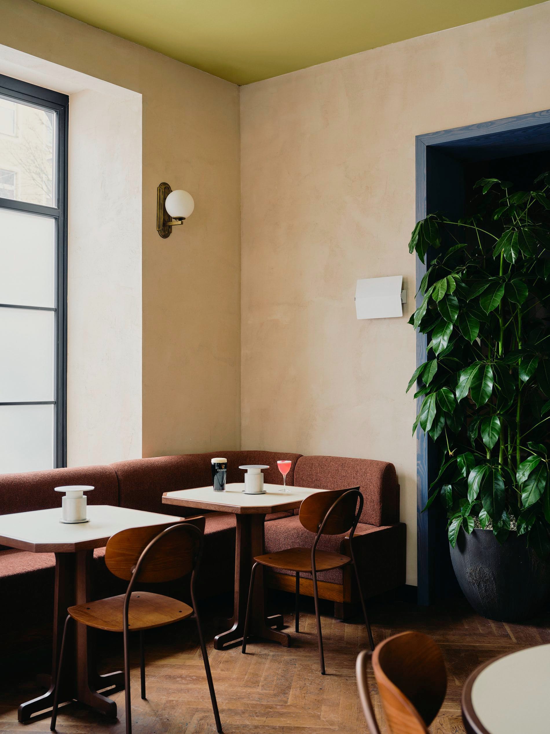 Im Restaurant Benedict treffen terracottafarbene Polsterbänke auf Holzstühle im Vintage-Stil.