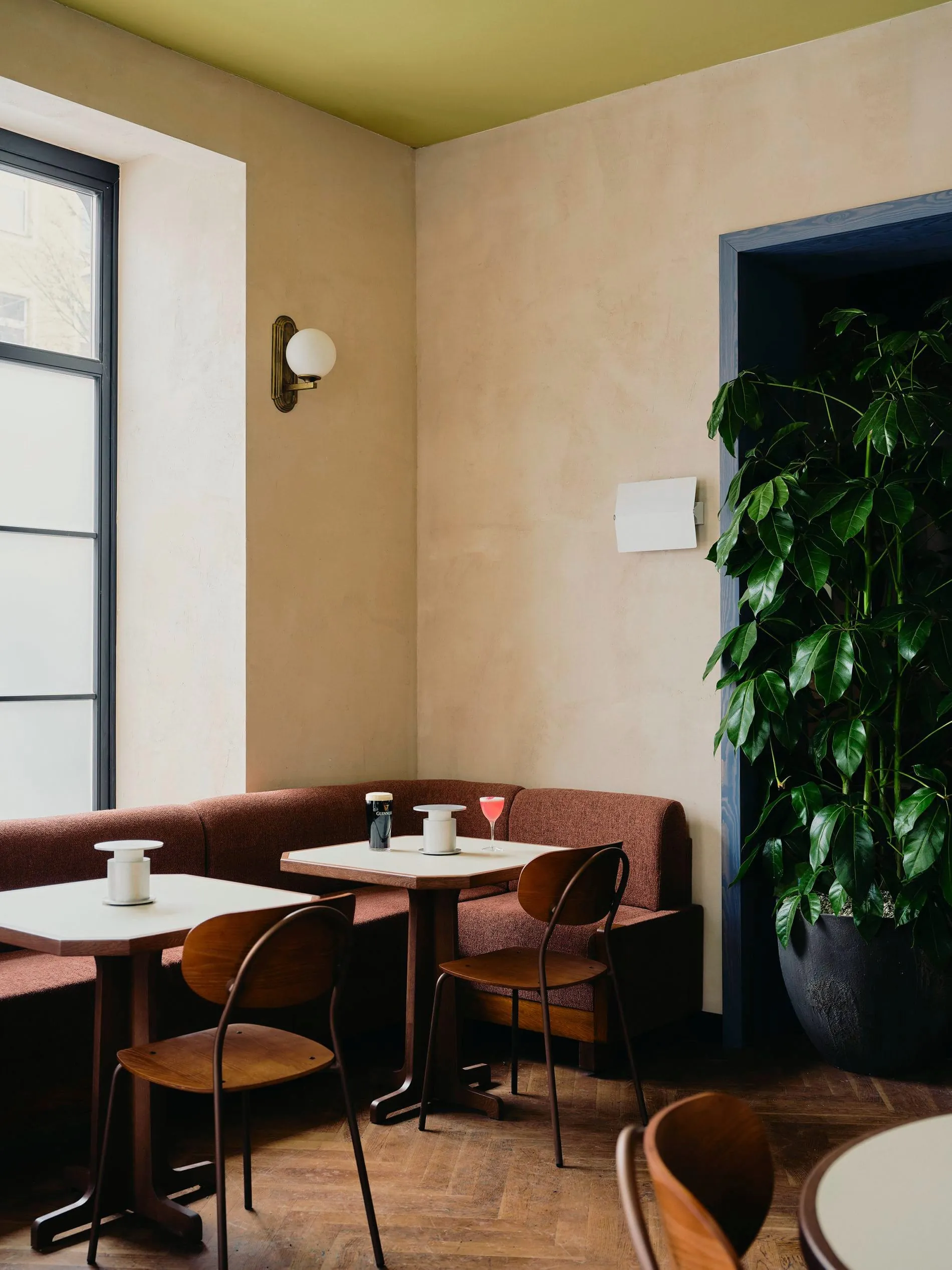 Im Restaurant Benedict treffen terracottafarbene Polsterbänke auf Holzstühle im Vintage-Stil.