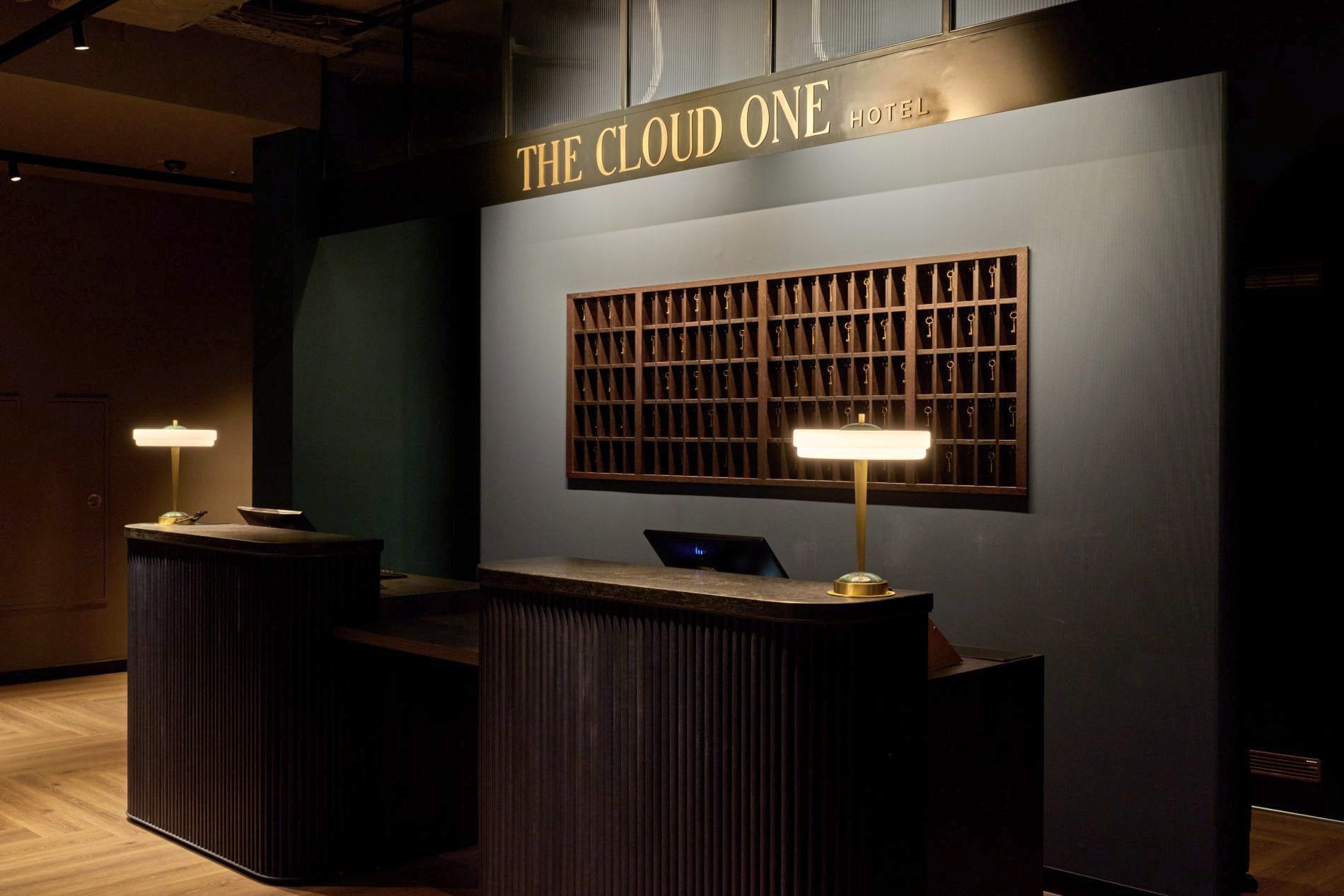 Rezeption des The Cloud One Frankfurt-Metropolitan mit goldenem Schriftzug, Schlüsselkasten und Messinglampen