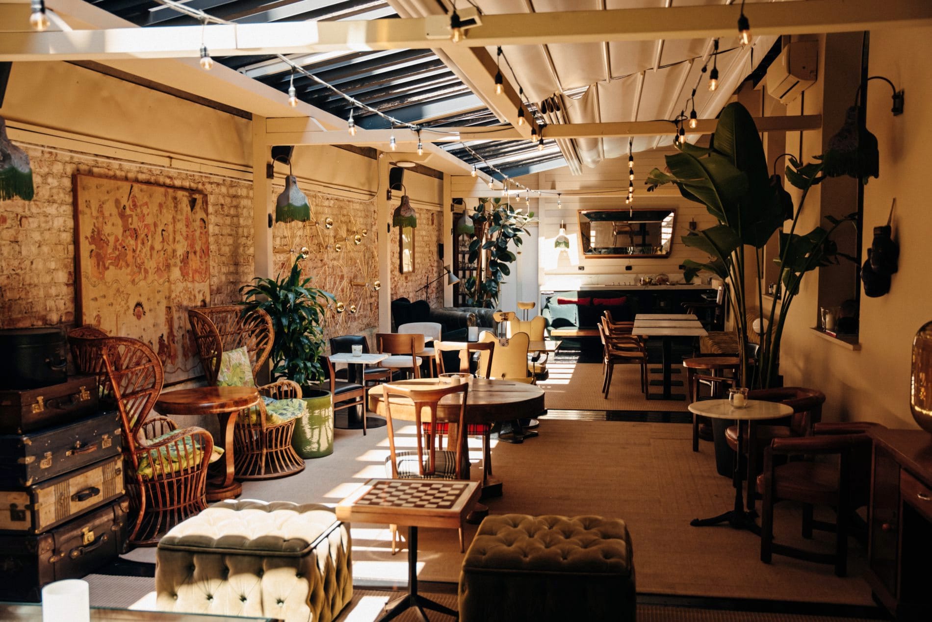 Die erweiterten Gemeinschaftsbereiche des Aethos Milan verbinden Rattanmöbel und freigelegte Backsteinwände zu einem Rückzugsort, der den Charakter des Navigli-Viertels widerspiegelt.