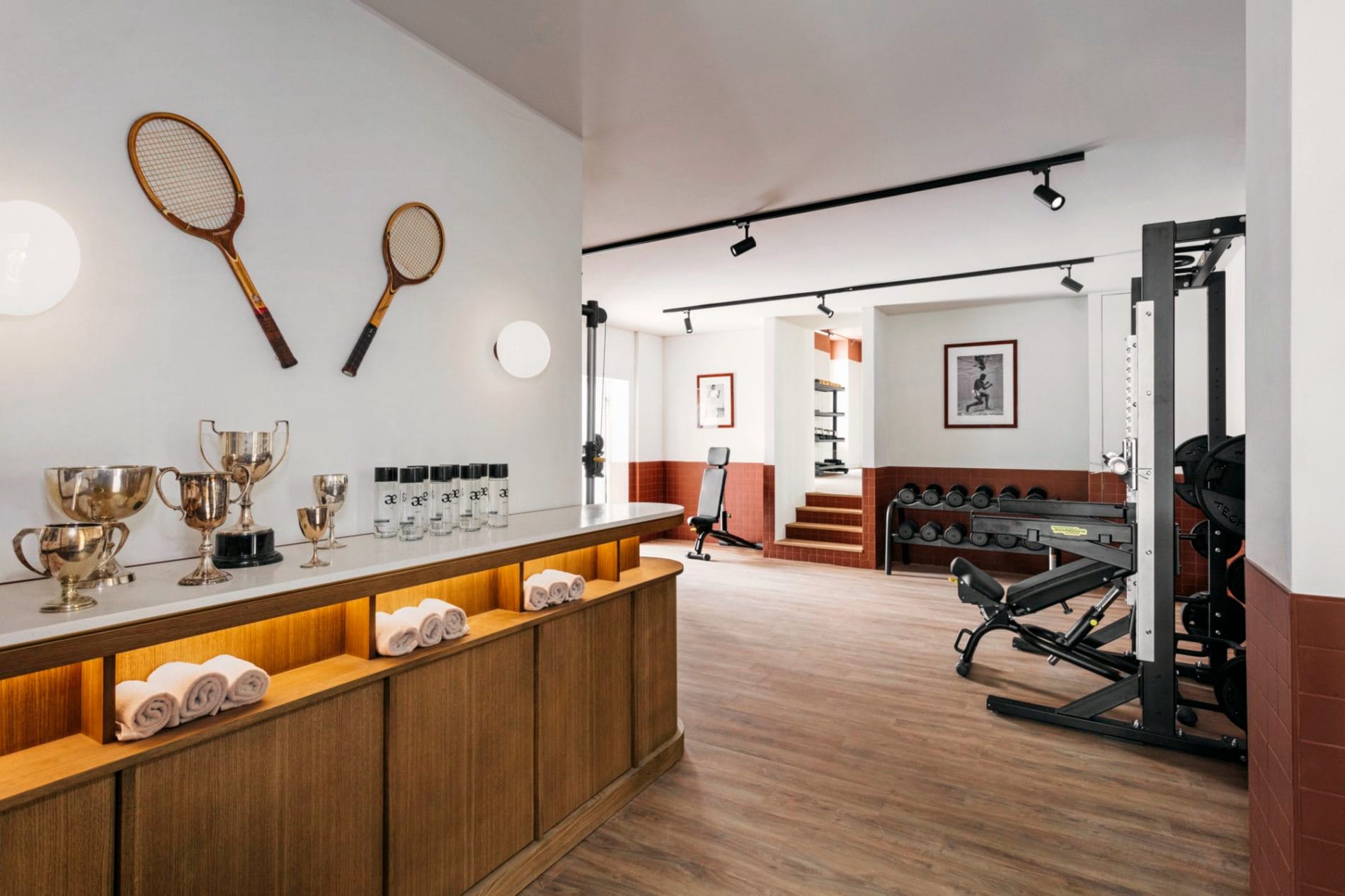 Vintage-Tennisschläger und Pokale an der Wand geben dem Fitnessbereich des Aethos Milan einen sportlich-nostalgischen Charakter.
