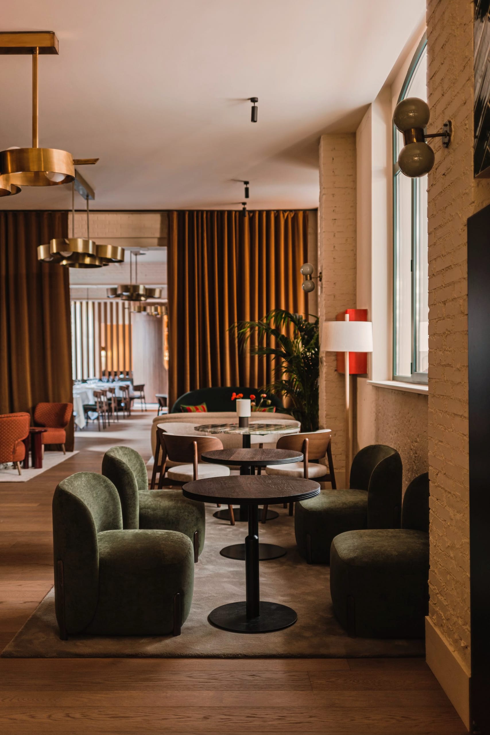 Im Members Club treffen waldgrüne Samtsessel, Messing-Pendelleuchten und ockerfarbene Samtvorhänge aufeinander.