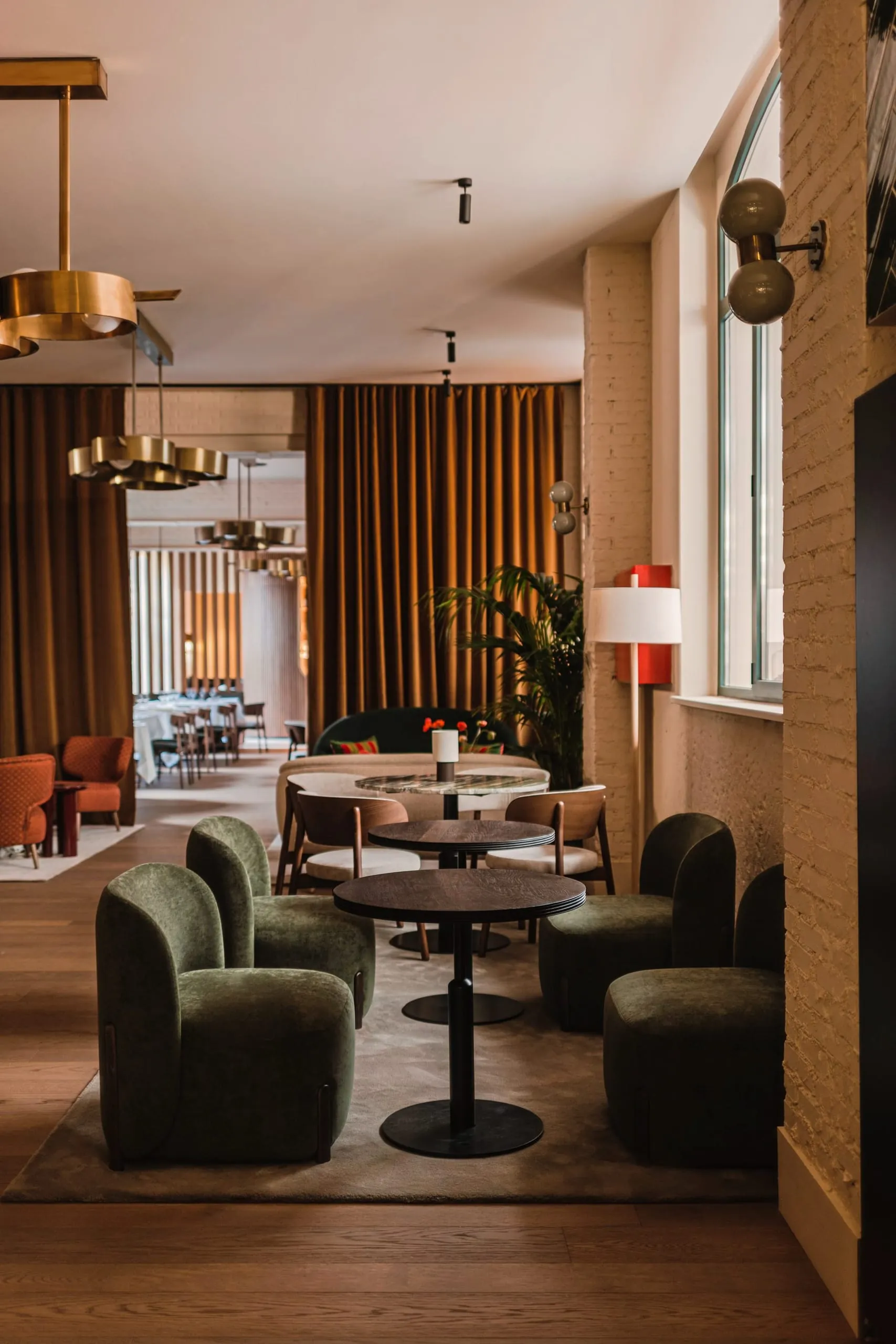 Im Members Club treffen waldgrüne Samtsessel, Messing-Pendelleuchten und ockerfarbene Samtvorhänge aufeinander.