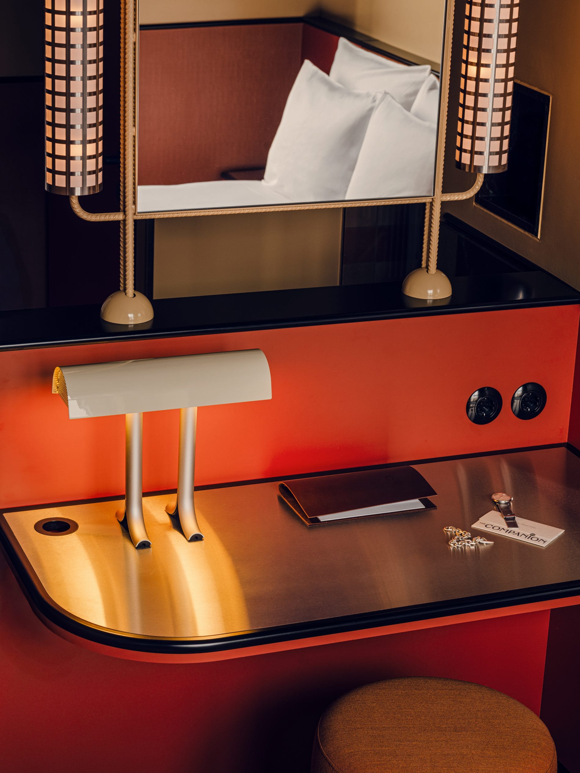 Der maßgefertigte Schreibtisch mit abgerundeter Messingkante, Designerlampe und Spiegel spiegelt den Anspruch des Hotels wider, jedes Detail als Teil eines Gesamtkunstwerks zu gestalten.