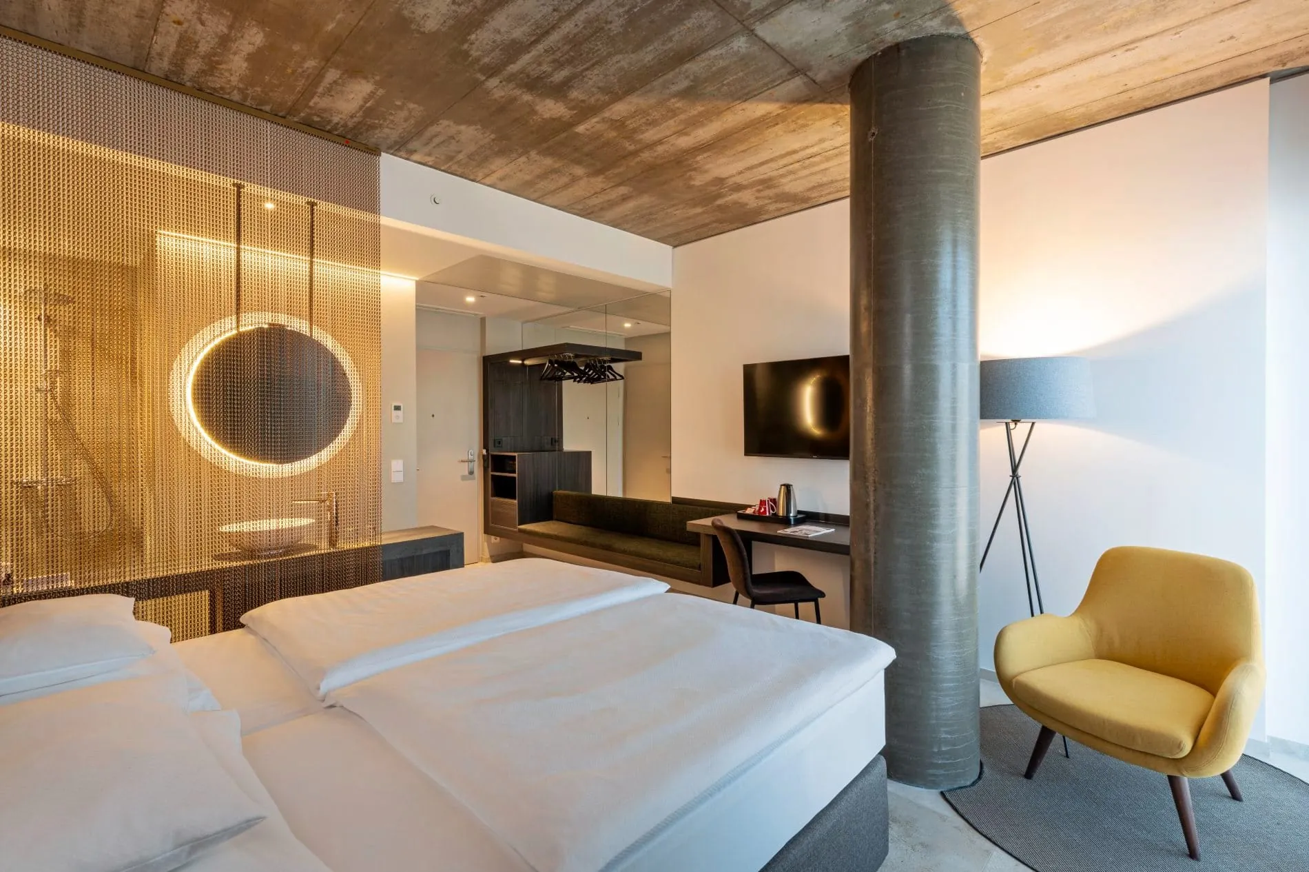 Sichtbeton, Metallkettenvorhänge und warmes Lichtdesign prägt das Interior Design.