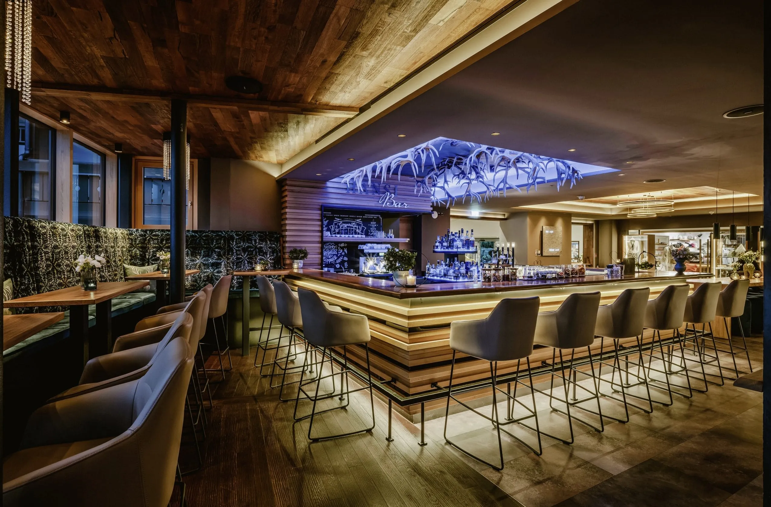 Merkmal der „Hansi Bar" im Bergkristall – Mein Resort im Allgäu in Osterstaufen ist das zentrale Atrium. Eine offene Gestaltung prägt das Ambiente der Bar.