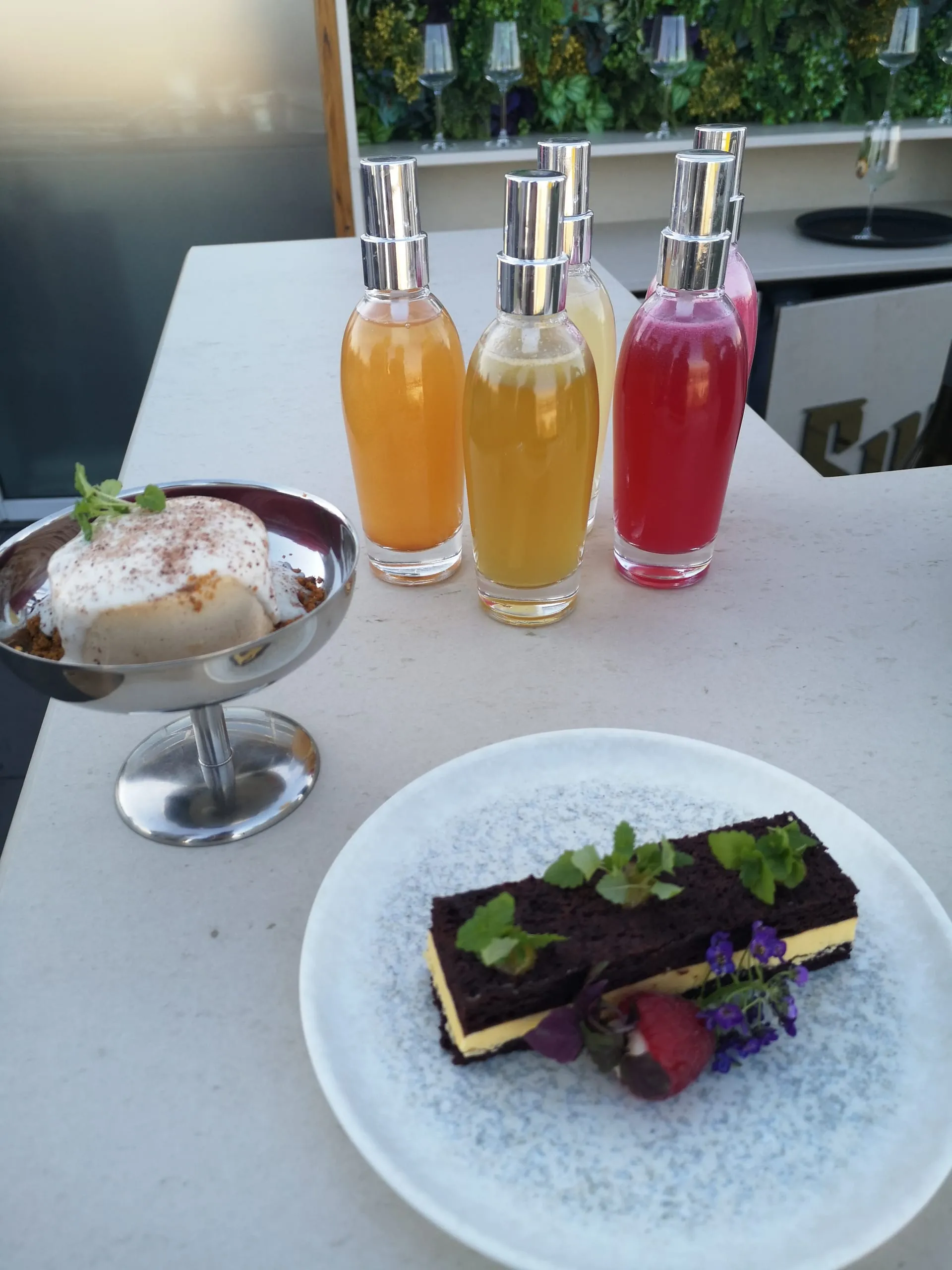 Alles aufeinander abgestimmt: Die mit Mango gefüllte Milchschnitte, der Affogato Botanico und die „Parfüm“-Fläschchen, um Drink-Aromen zu versprühen.