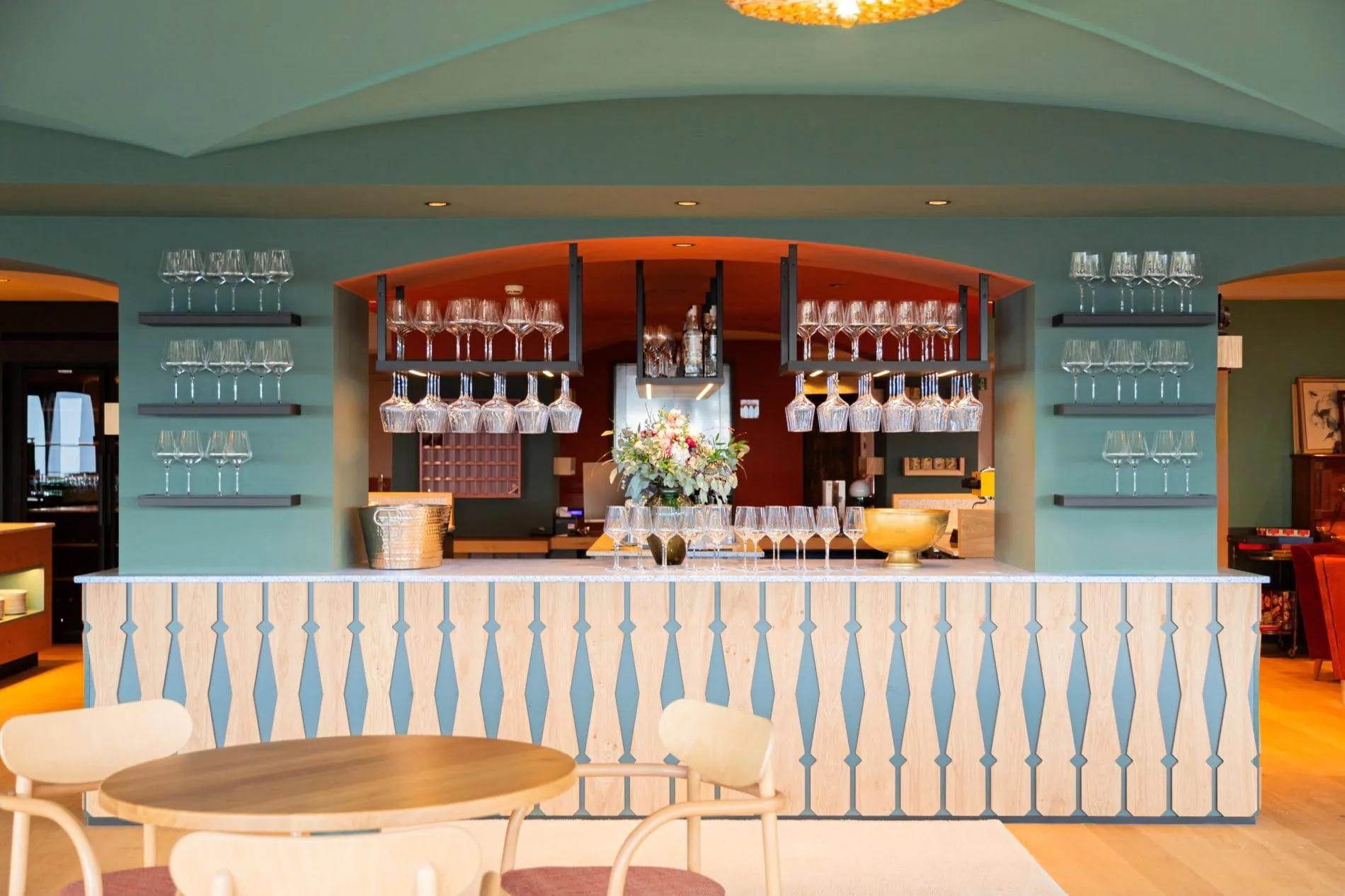 Treffpunkt für einen Apertitiv: Die zentrale Bar mit charakteristischem Holzgeländer-Design und mintgrünem Gewölbe.