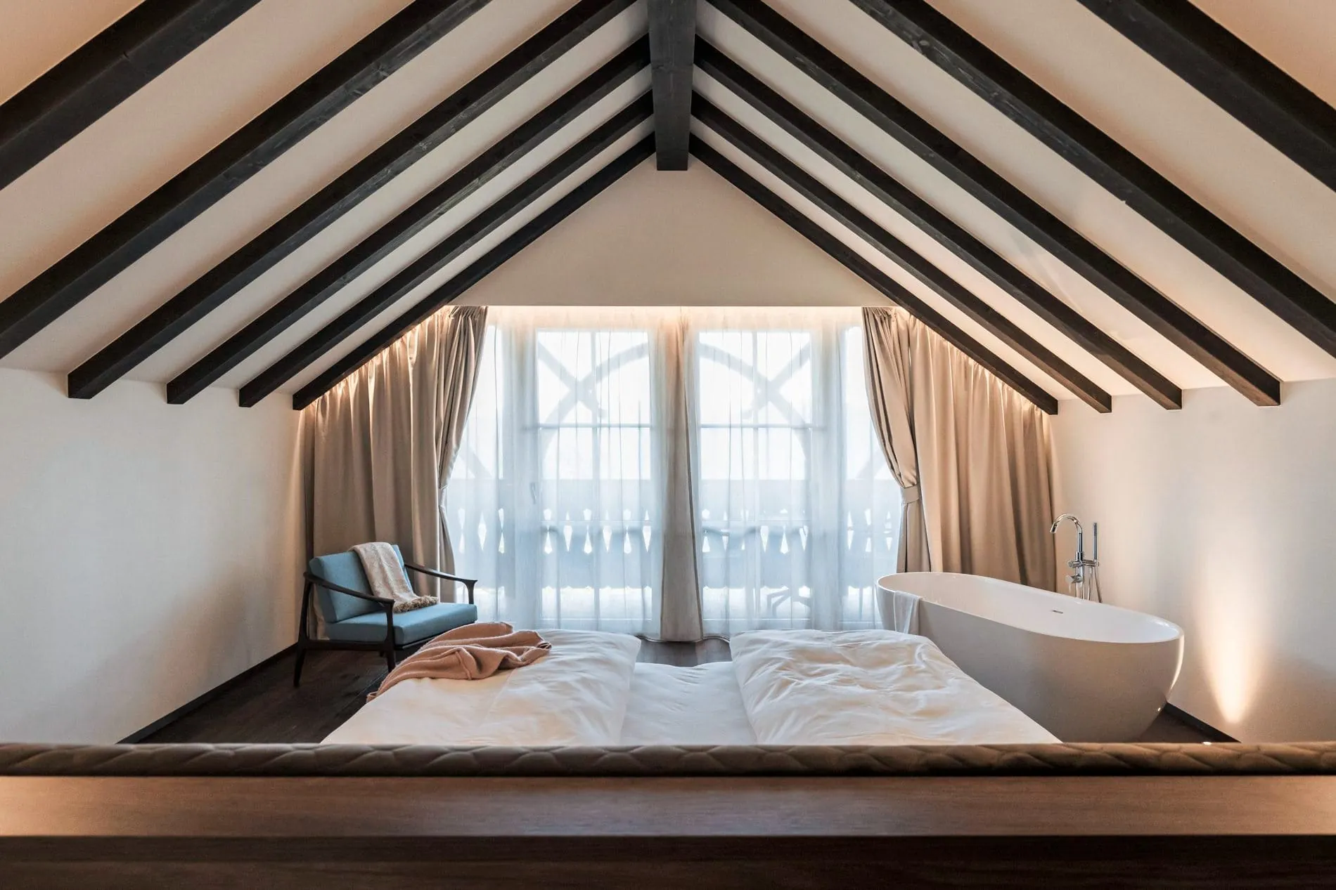 Die Margherita Suite vereint unter offenem Giebeldach Schlafbereich und freistehende Badewanne.