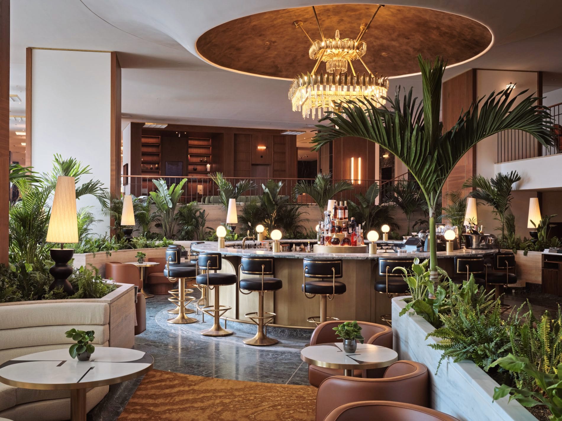 Die Athenian Lounge serviert Cocktails und Tagesgerichte in einer Atmosphäre aus tropischen Pflanzen, Messingdetails und einem markanten Kronleuchter.