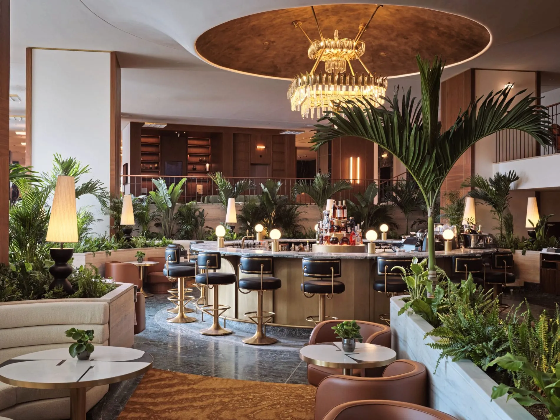 Die Athenian Lounge serviert Cocktails und Tagesgerichte in einer Atmosphäre aus tropischen Pflanzen, Messingdetails und einem markanten Kronleuchter.