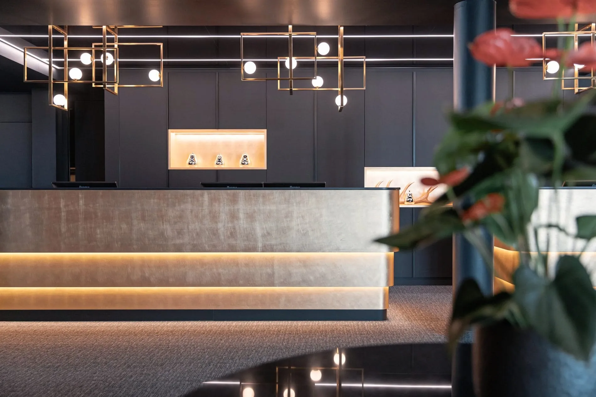 Die elegant gestaltete Rezeption empfängt Gäste mit moderner Architektur und stimmungsvoller Beleuchtung.