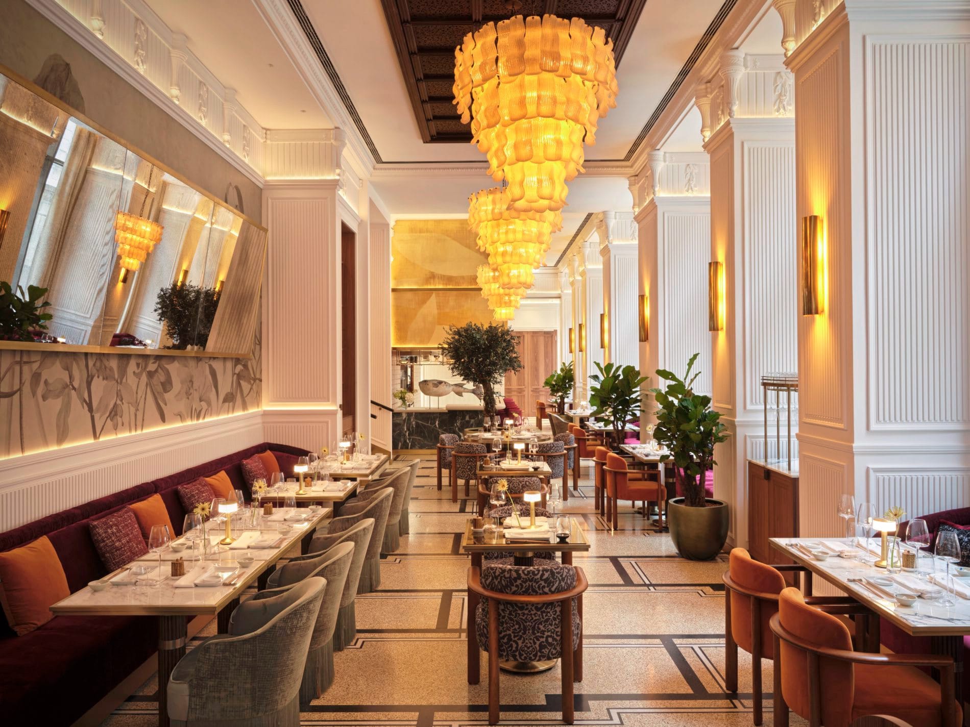 Der hohe Hauptsaal des 99 Sushi Bar & Restaurant beeindruckt mit kaskadenartigen Murano-Glas-Kronleuchtern und einer offenen Showküche im Hintergrund.