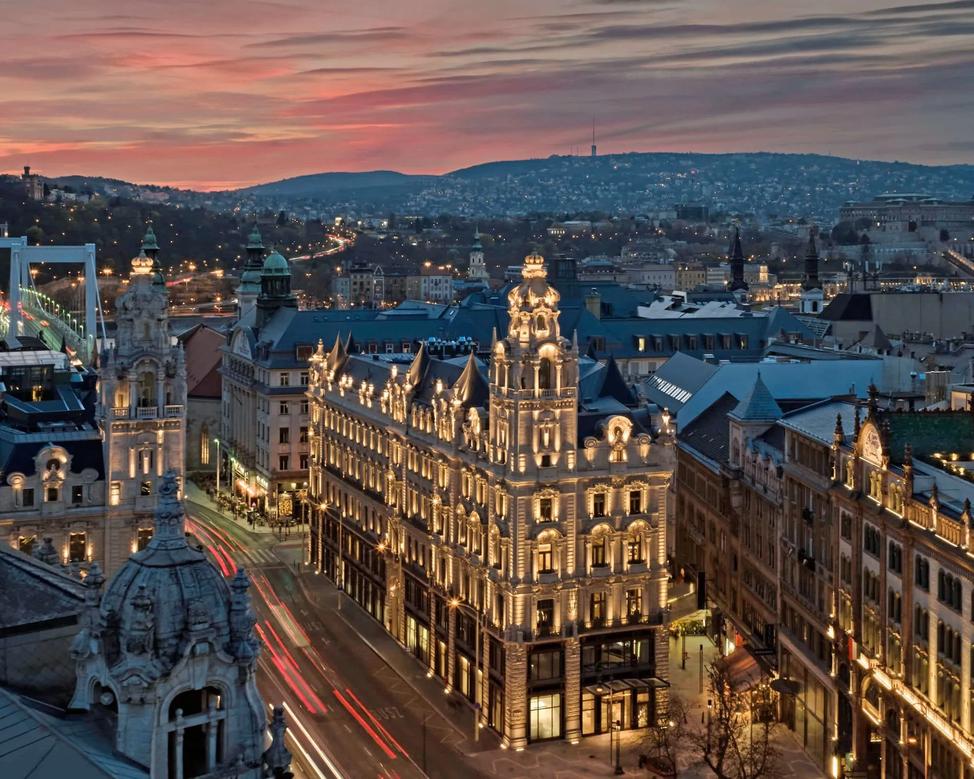 Bei Nacht erstrahlt das Klotild Palais im warmen Licht und bildet einen markanten Akzent in Stadtbild von Budapest.