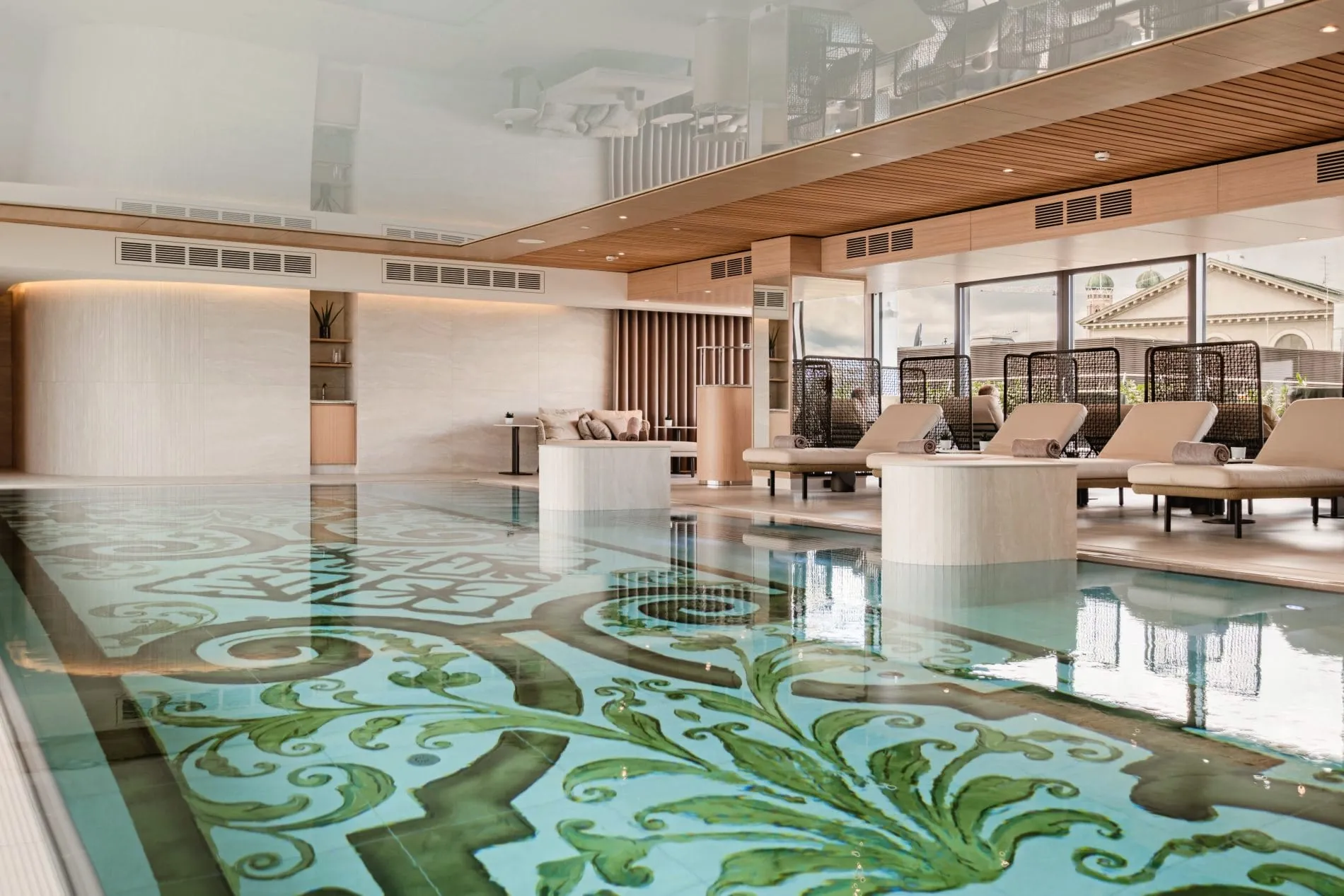 Der Rooftop-Pool des Kempinski The Spa verbindet historische Designelemente mit modernem Ambiente und bietet Ausblick über die Münchner Altstadt.