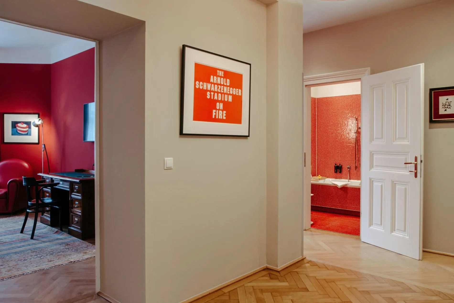 Kunstwerk von Jonathan Monk mit der Aufschrift „The Arnold Schwarzenegger Stadium on fire“ im Flur der Suite „Harry K. Room“ im Altstadt Vienna.