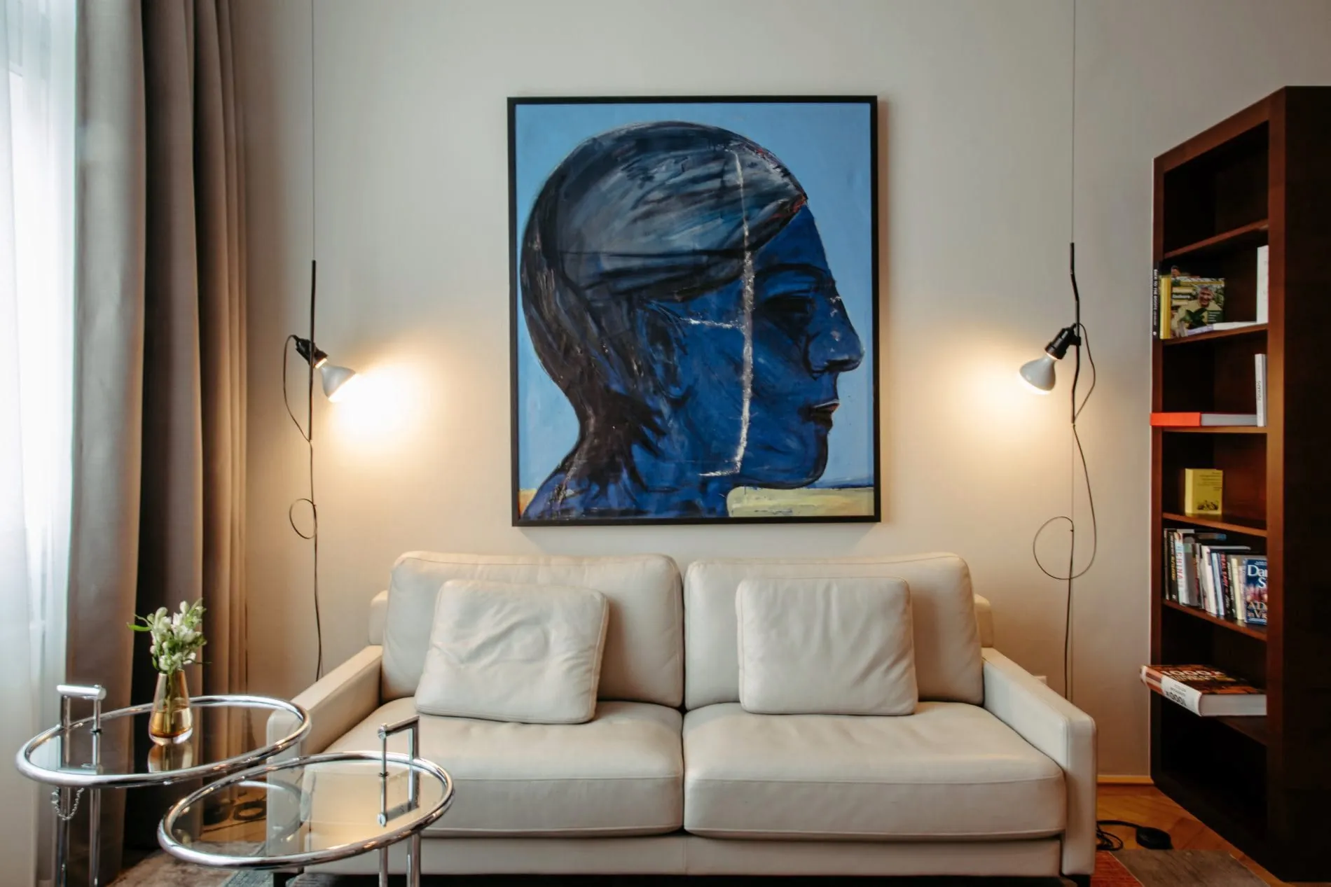 Wohnbereich der Suite im Altstadt Vienna mit Ledersofa, Sideboard, Bücherwand und Glastischen von Eileen Gray.