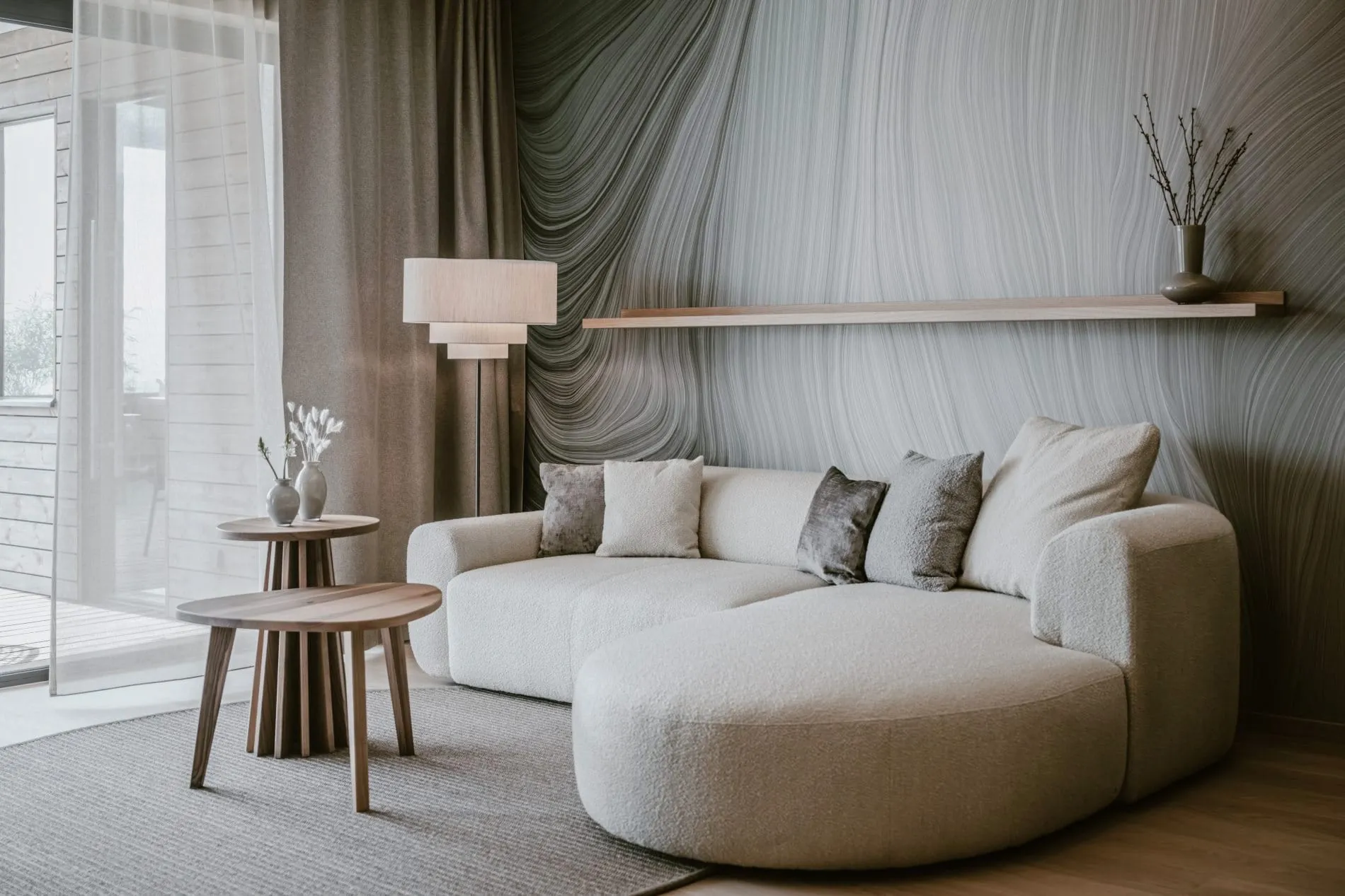 Der offene Wohnbereich der 65 Quadratmeter großen Seesuiten lädt mit weichem Bouclé-Sofa und Naturstoffen zum Entspannen ein.