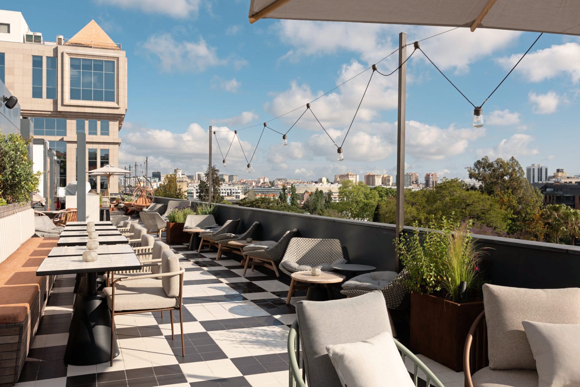 Die Rooftop-Bar im fünften Stock kombiniert klassische Schachbrettfliesen mit modernem Outdoor-Mobiliar und bietet einen weiten Blick über Lissabons Dächer.